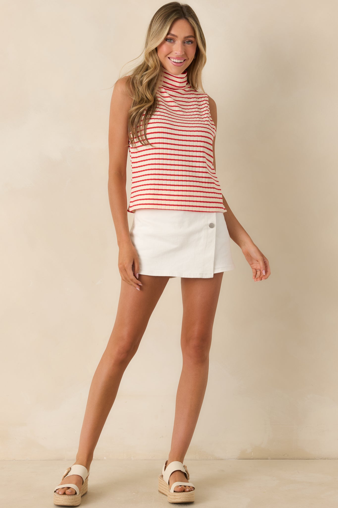 Sleeveless red and white striped top featuring a structured mockneck and comfortable fitted shape.