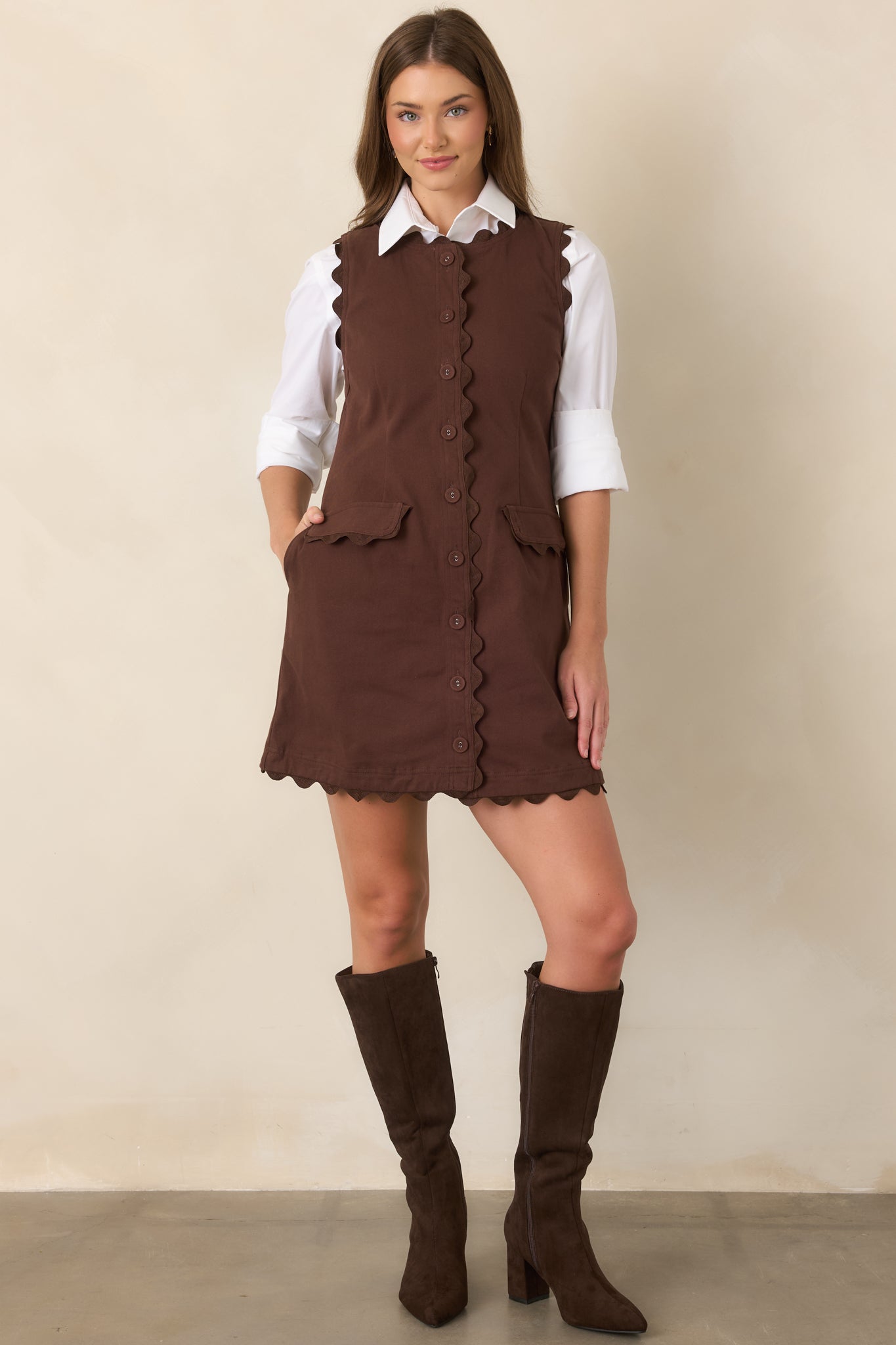 Sleeveless mini dress showcasing tonal ric rac along the neckline, armholes, button placket, pockets, and hem for a polished finish.