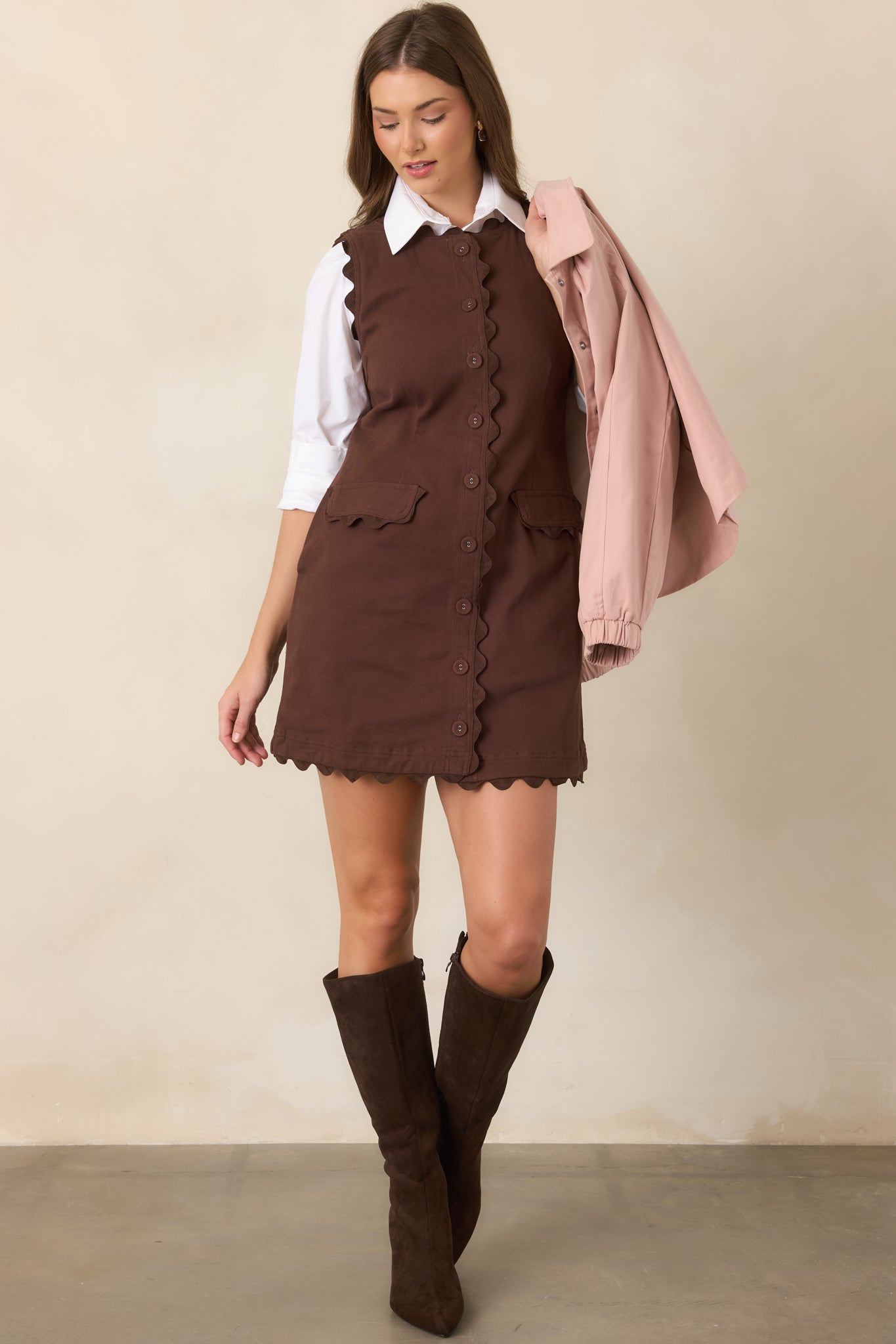 Vintage-inspired sleeveless mini dress featuring a button-front placket, defined waist seams, tonal trim, and compact front pockets.
