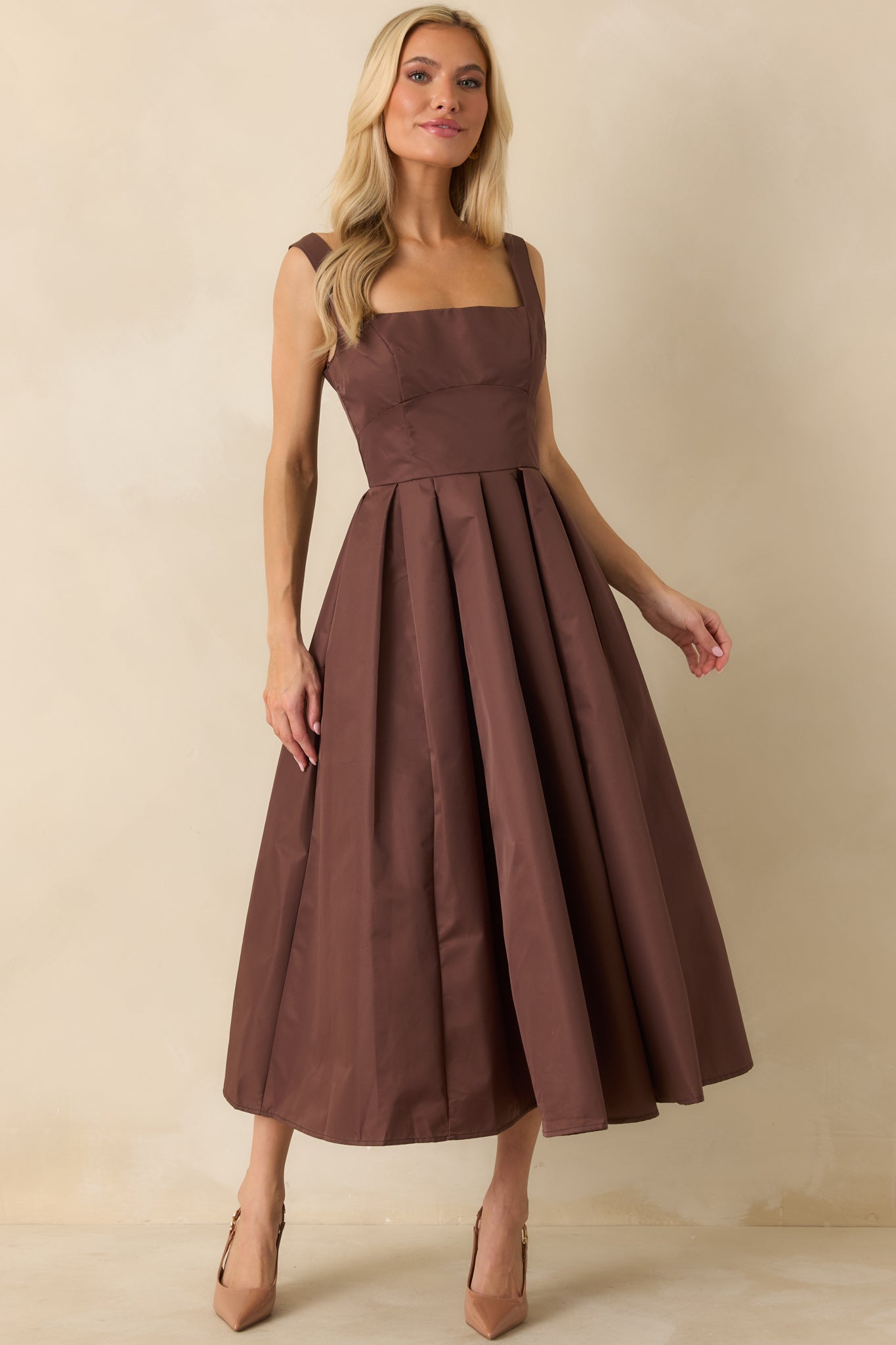 Sleeveless woven dress showing front silhouette and structured pleated detailing.