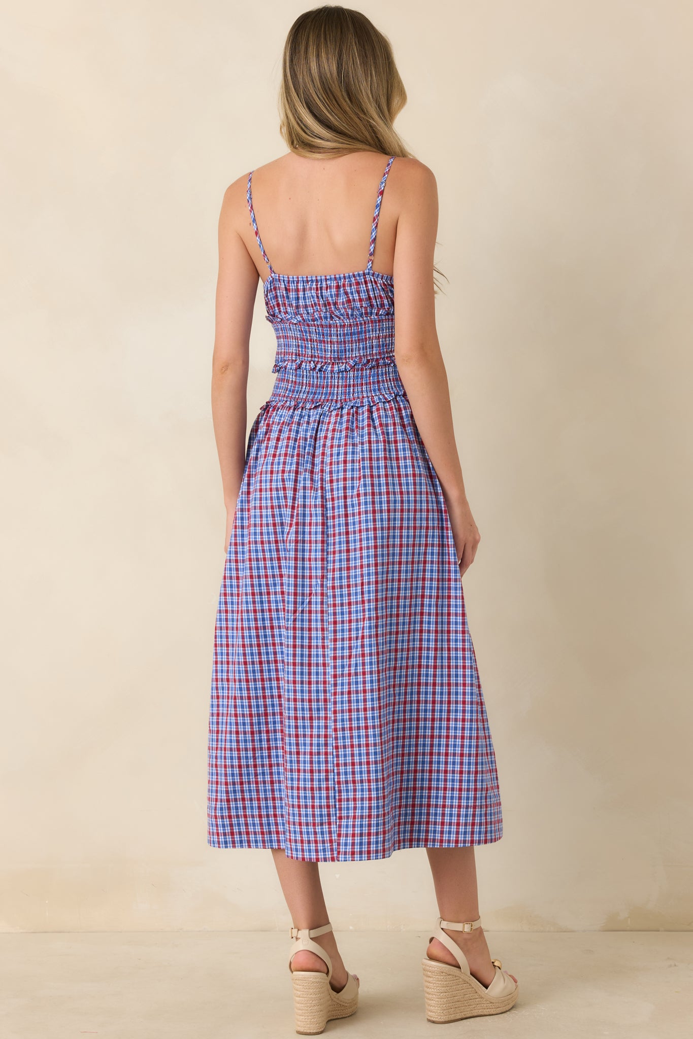 Rear view of the dress highlighting the smocked bodice, adjustable straps, gathered skirt, and relaxed flowing silhouette.