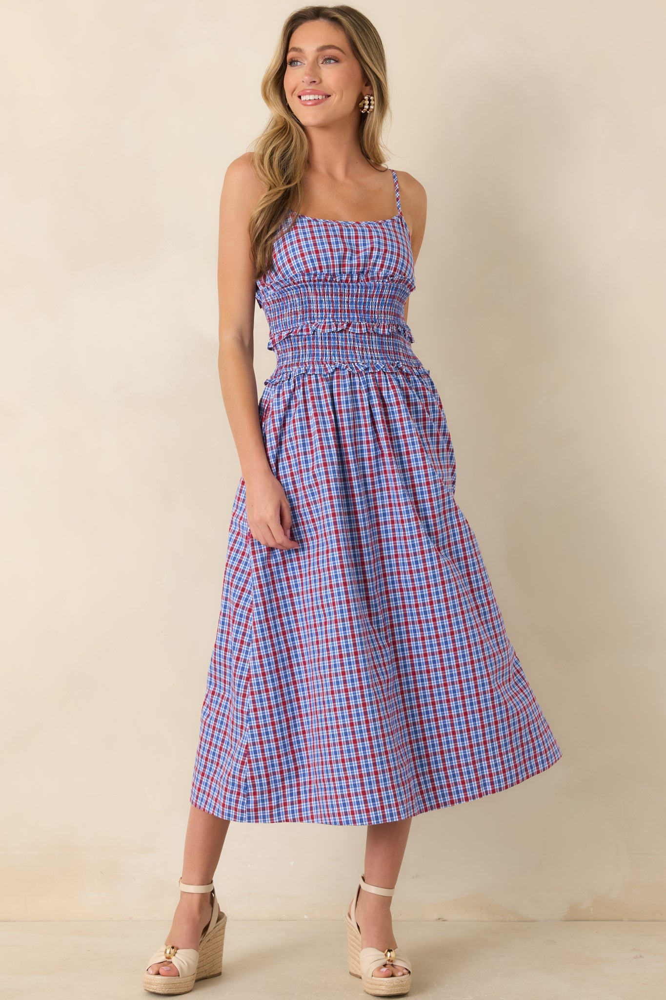 Smocked bodice dress featuring delicate adjustable straps, soft waist ruffle accents, a gathered skirt, and a relaxed feminine silhouette.