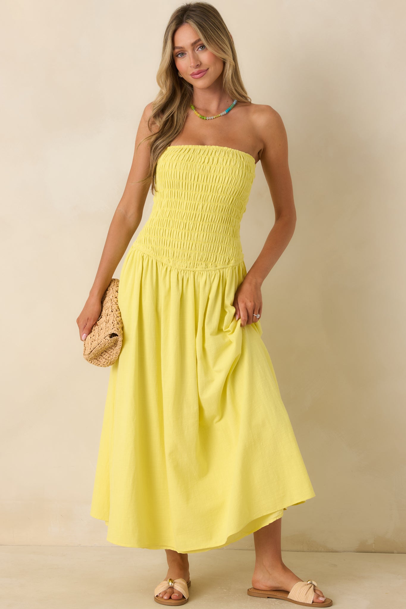 Yellow strapless maxi dress featuring a smocked elastic bodice, flowy gathered skirt, and lightweight cotton construction.