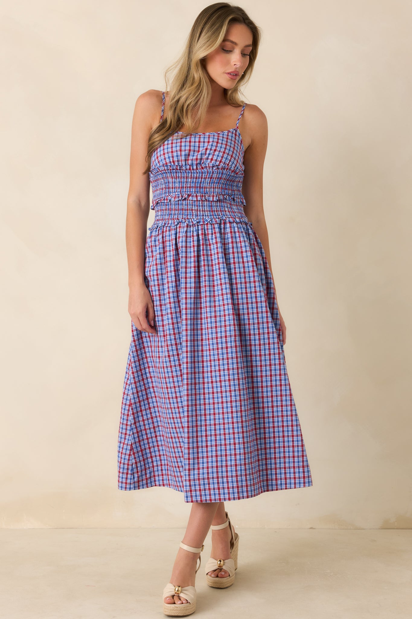 Easygoing dress showcasing a textured smocked bodice, ruffled waist detailing, adjustable shoulder straps, and flowing skirt movement.