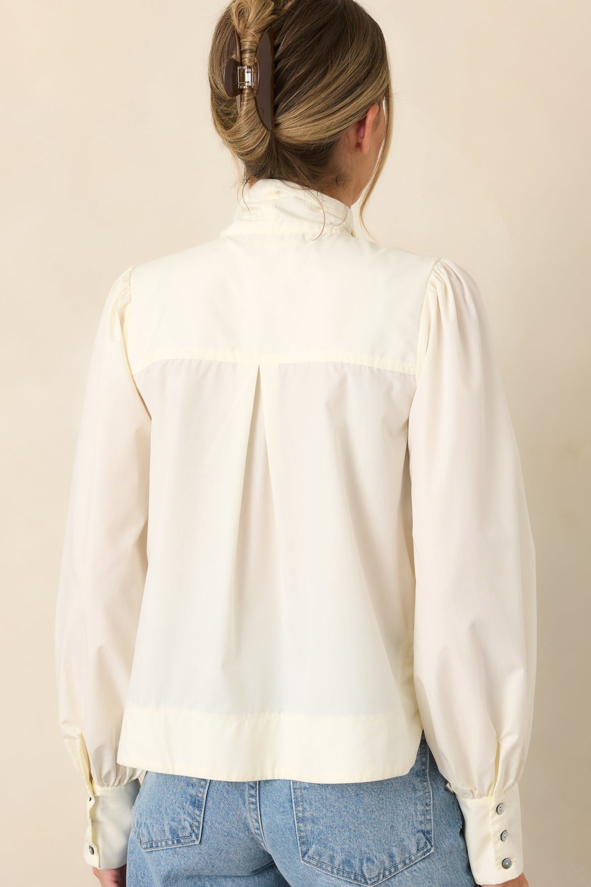 Rear view of the smooth blend blouse showcasing the gathered shoulders, voluminous balloon sleeves, and wide button cuffs.
