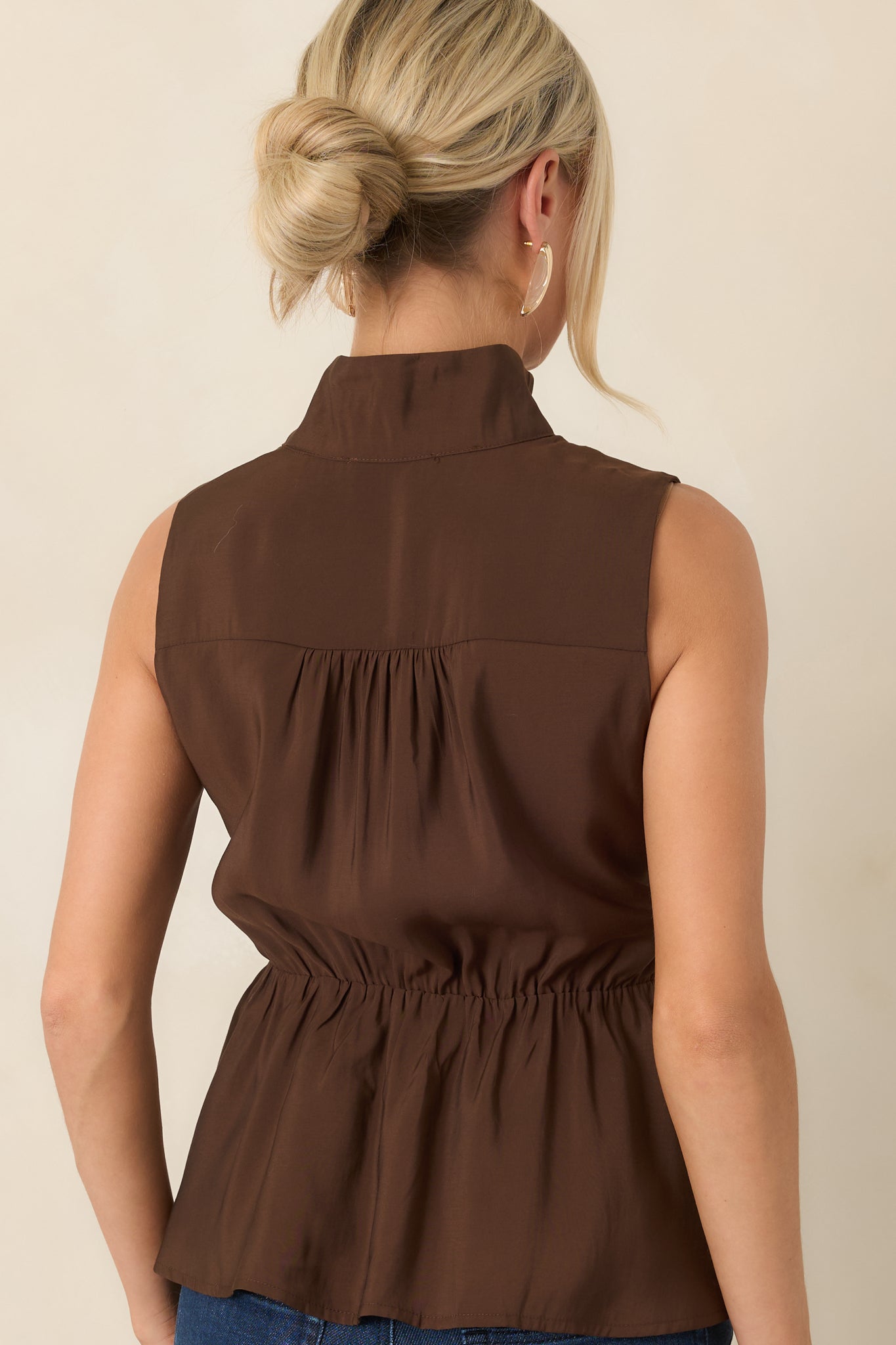 Rear view of the smooth top featuring an elasticized waist, full lining, and softly flared peplum hem.