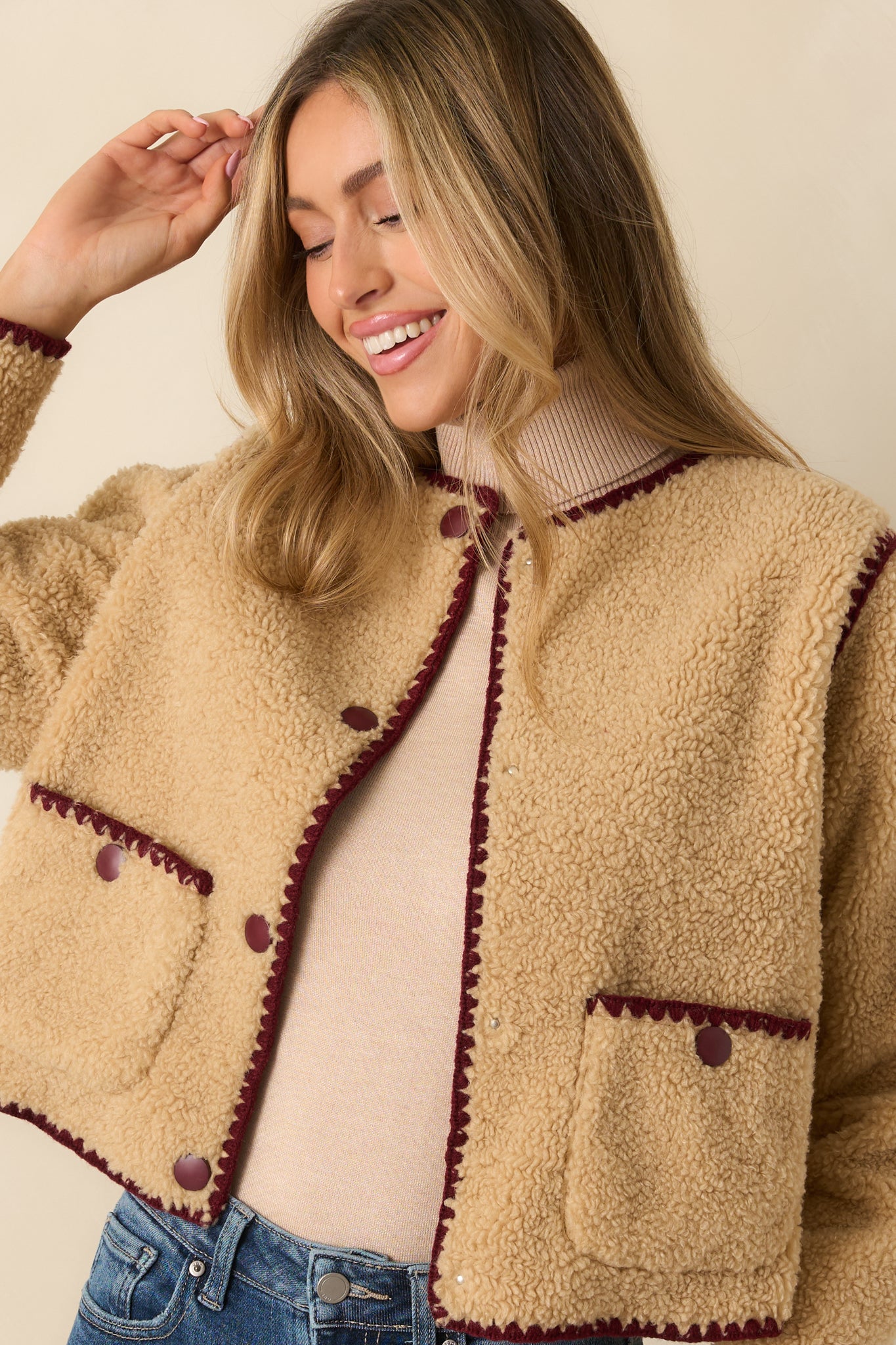 Snap-button front showcased with textured beige sherpa and clean contrast trim.