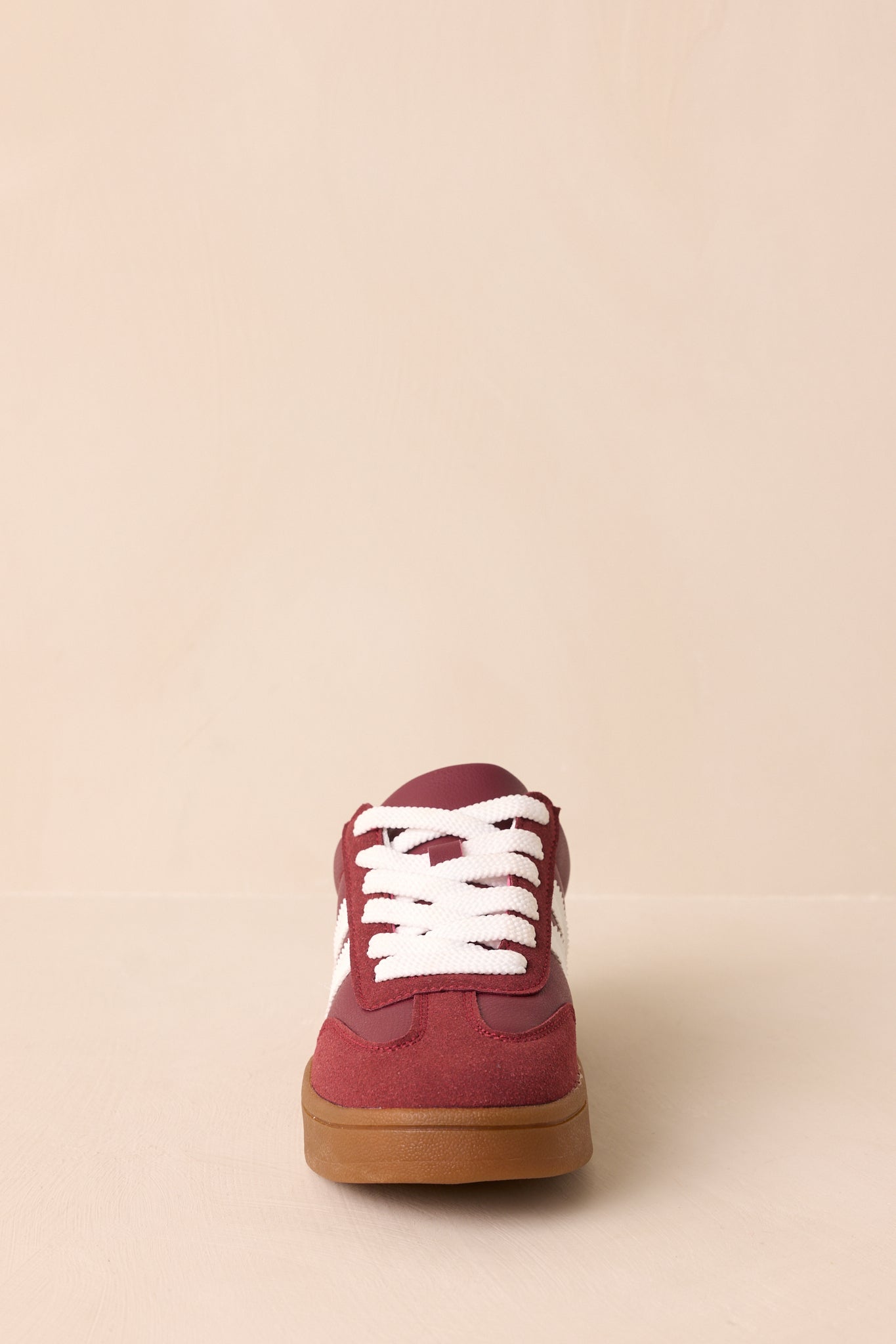A straight-on front view of the sneaker highlighting the lace-up front, round toe, and gum rubber sole.