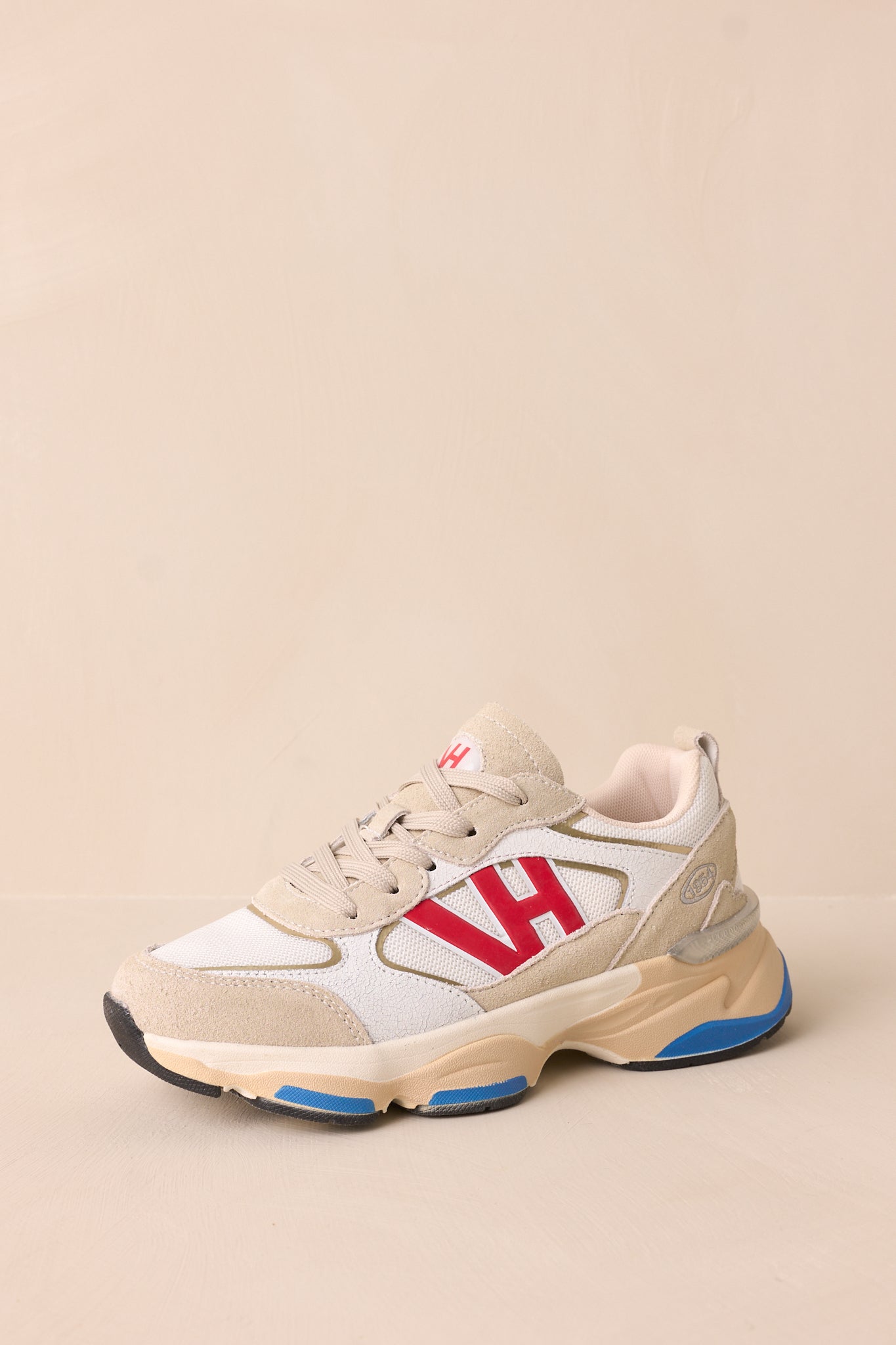 Angled top-side view showing the lace-up front, color contrast, and thick beige sole with blue accents.