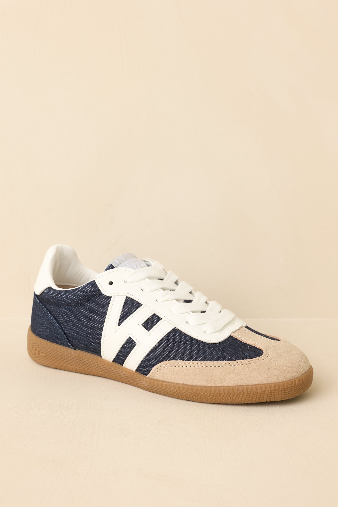 Front view of sneakers showing classic lace-up design and layered mixed-material construction.