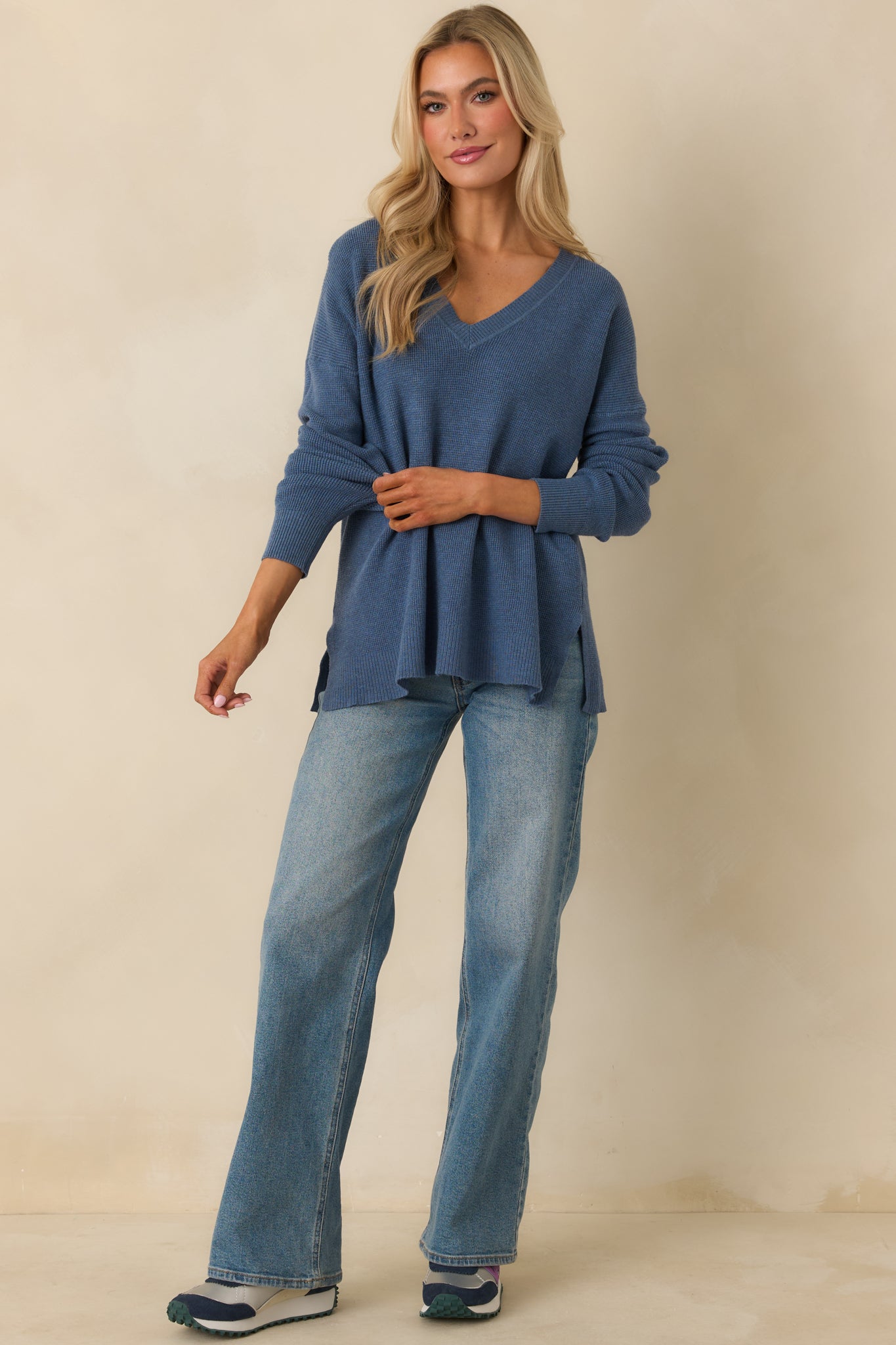 Soft blue knit sweater featuring ribbed cuffs, split hem bottom, and casual silhouette.