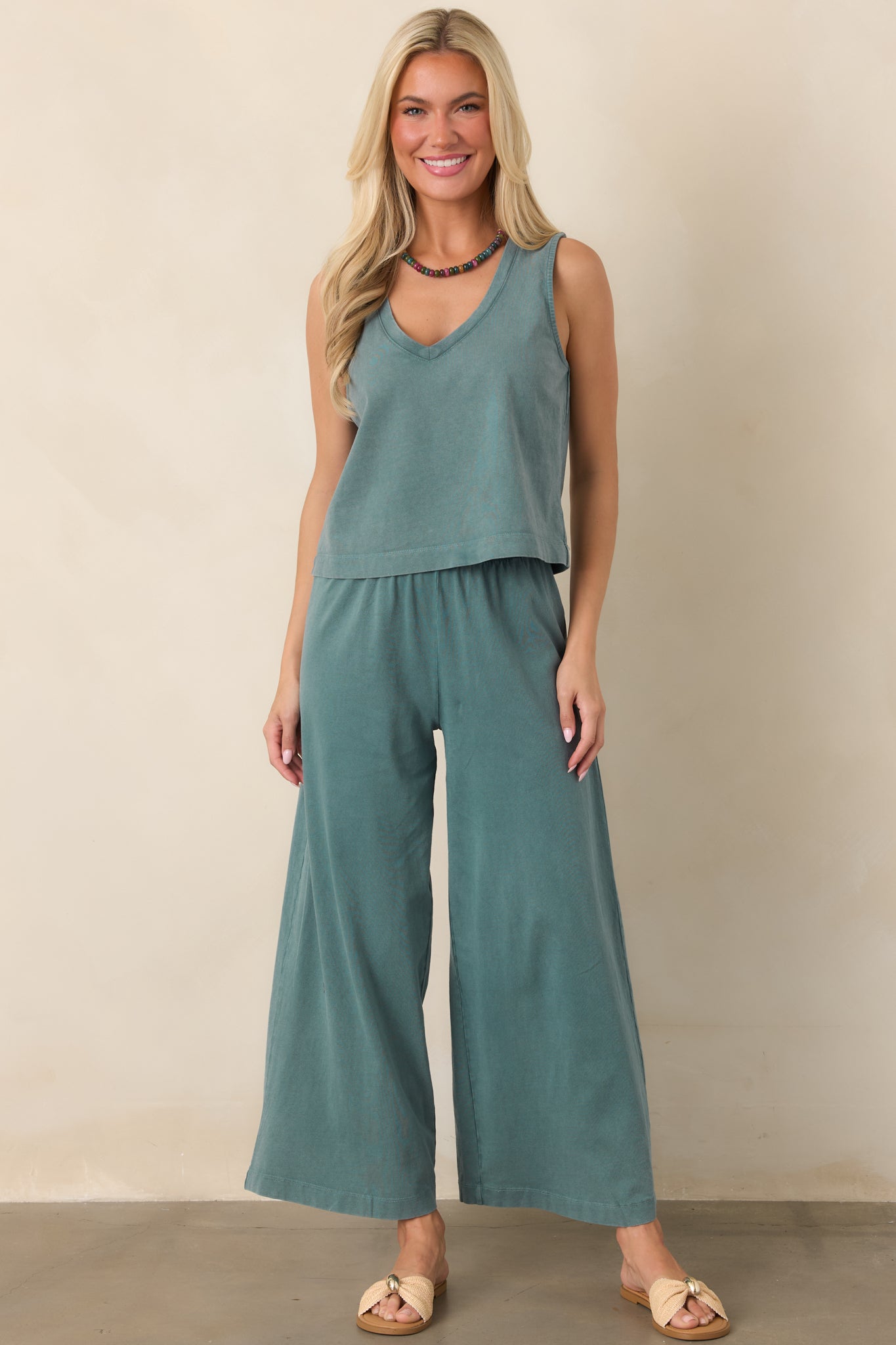 Soft emerald green cotton top featuring a sleeveless tank silhouette, V-neckline, and easy relaxed shape with a cropped hem.