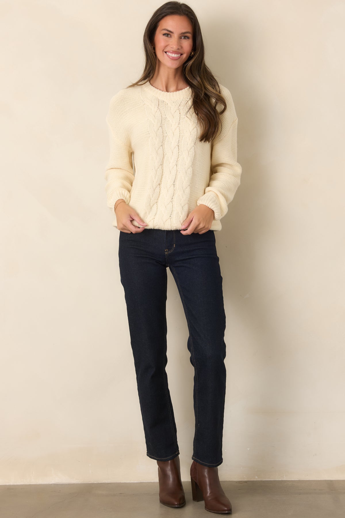 Soft ivory knit sweater featuring a cable knit front, classic crew neckline, and easy relaxed silhouette.