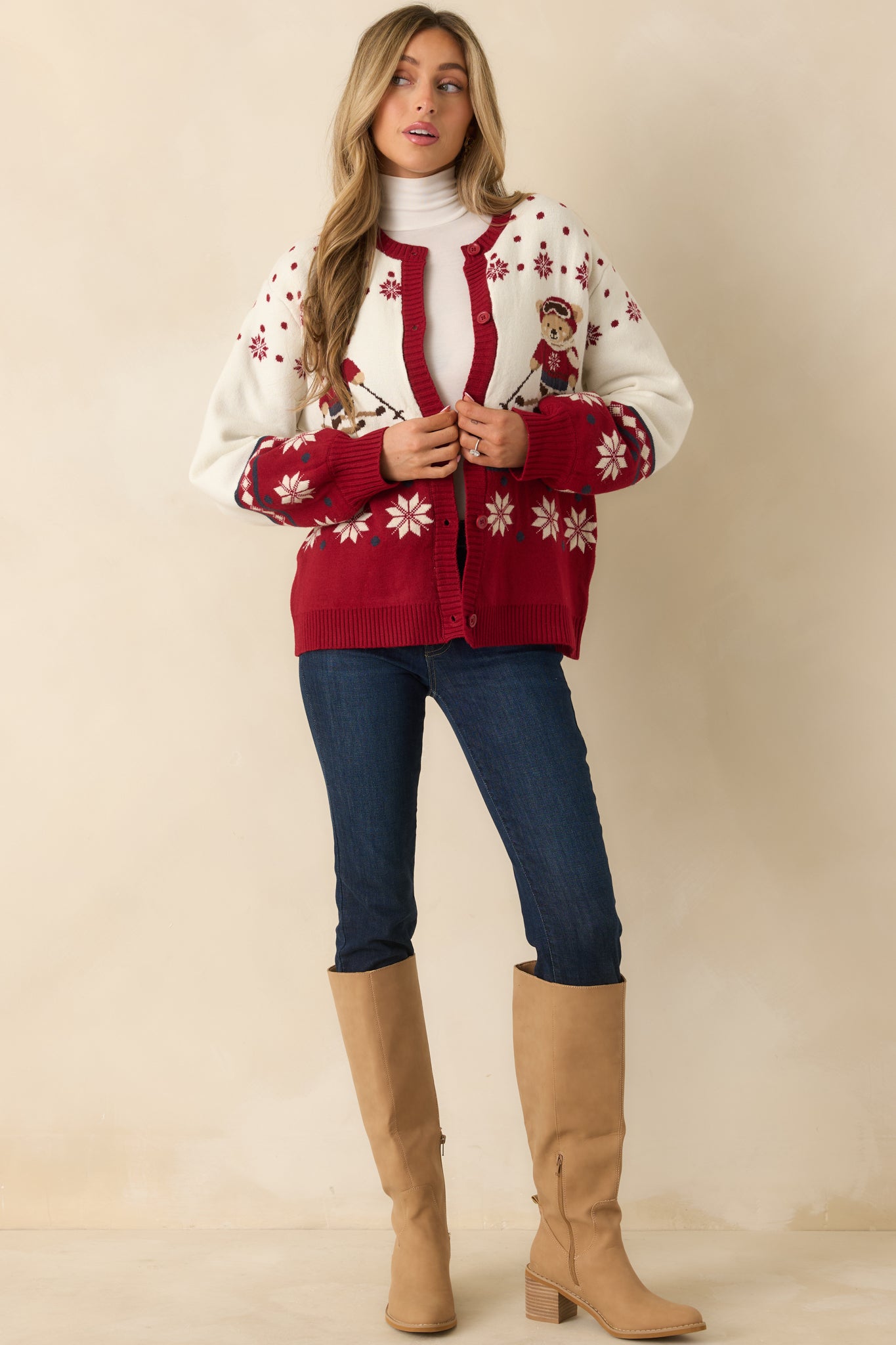 Soft knit cardigan featuring skiing bear graphics, button-front styling, and long sleeves in an easy layering silhouette.