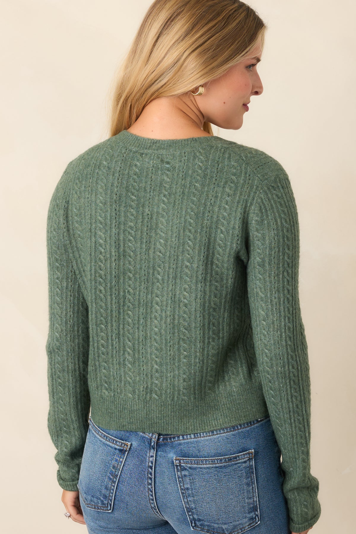 Rear of the slightly cropped knit cardigan showing the smooth back, long sleeves, and ribbed hem and cuffs.