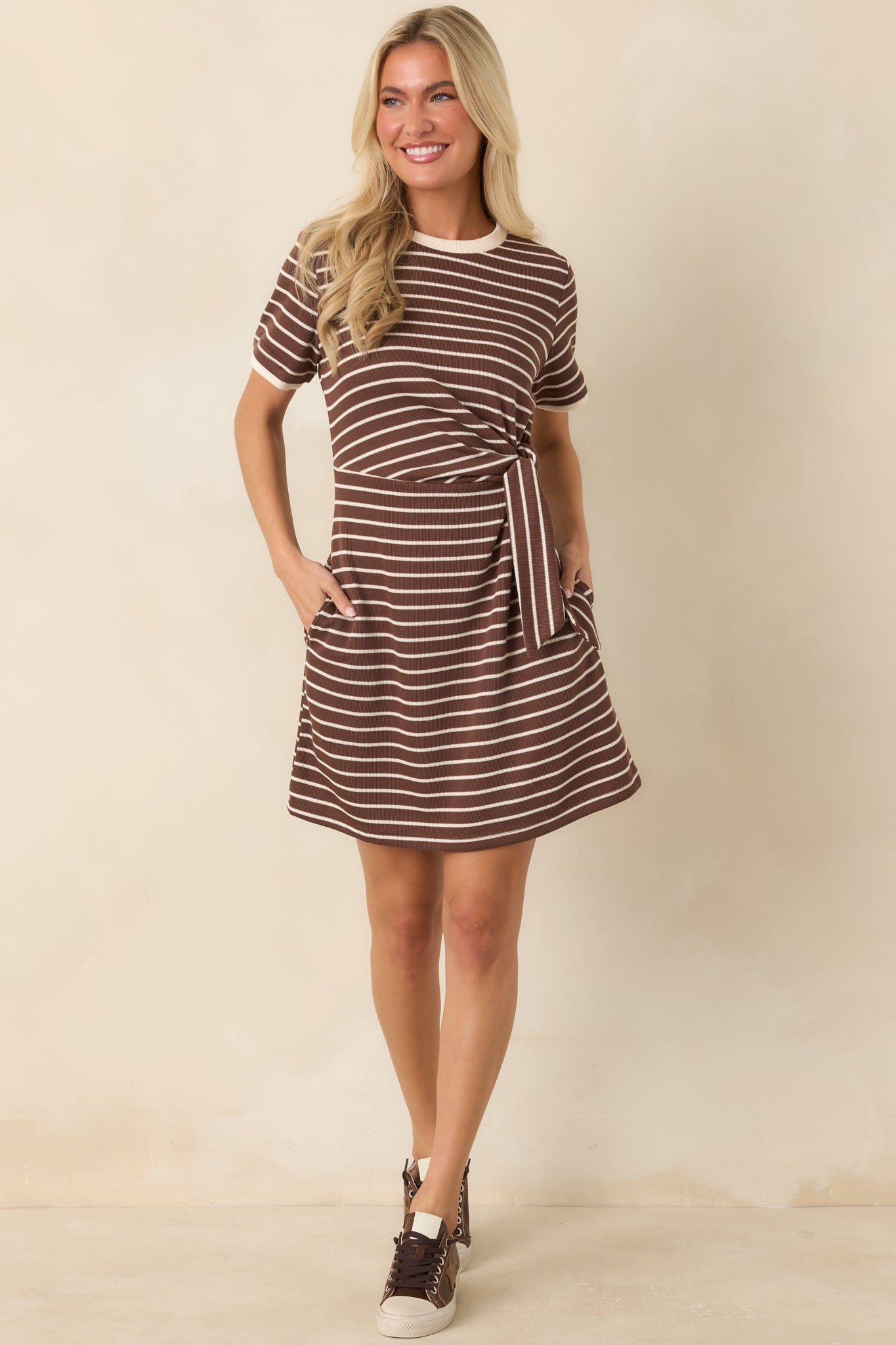 Soft knit mini dress designed with classic horizontal stripes, a waist-defining side tie, and a sporty crew neckline.