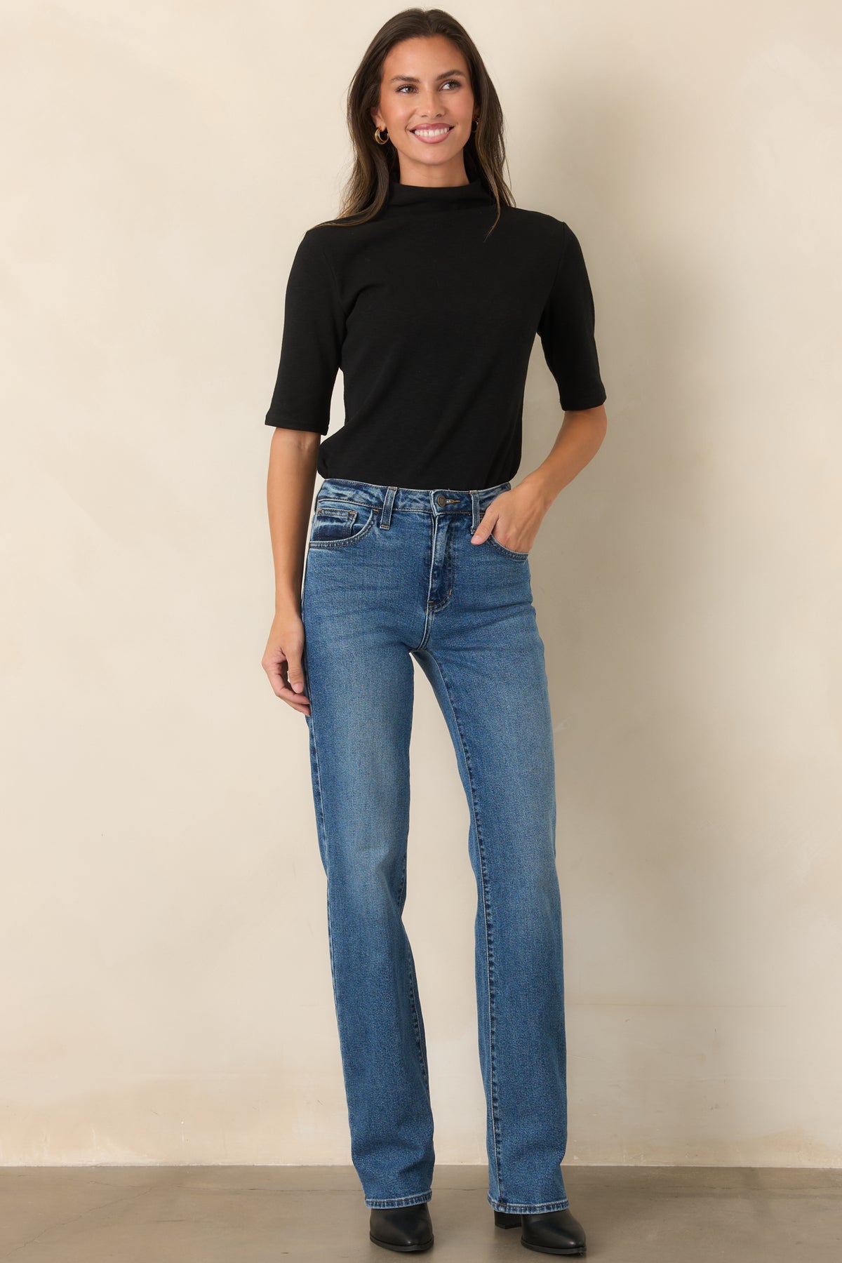 Soft knit construction shapes this polished top with a tall turtleneck and neatly finished short sleeves.