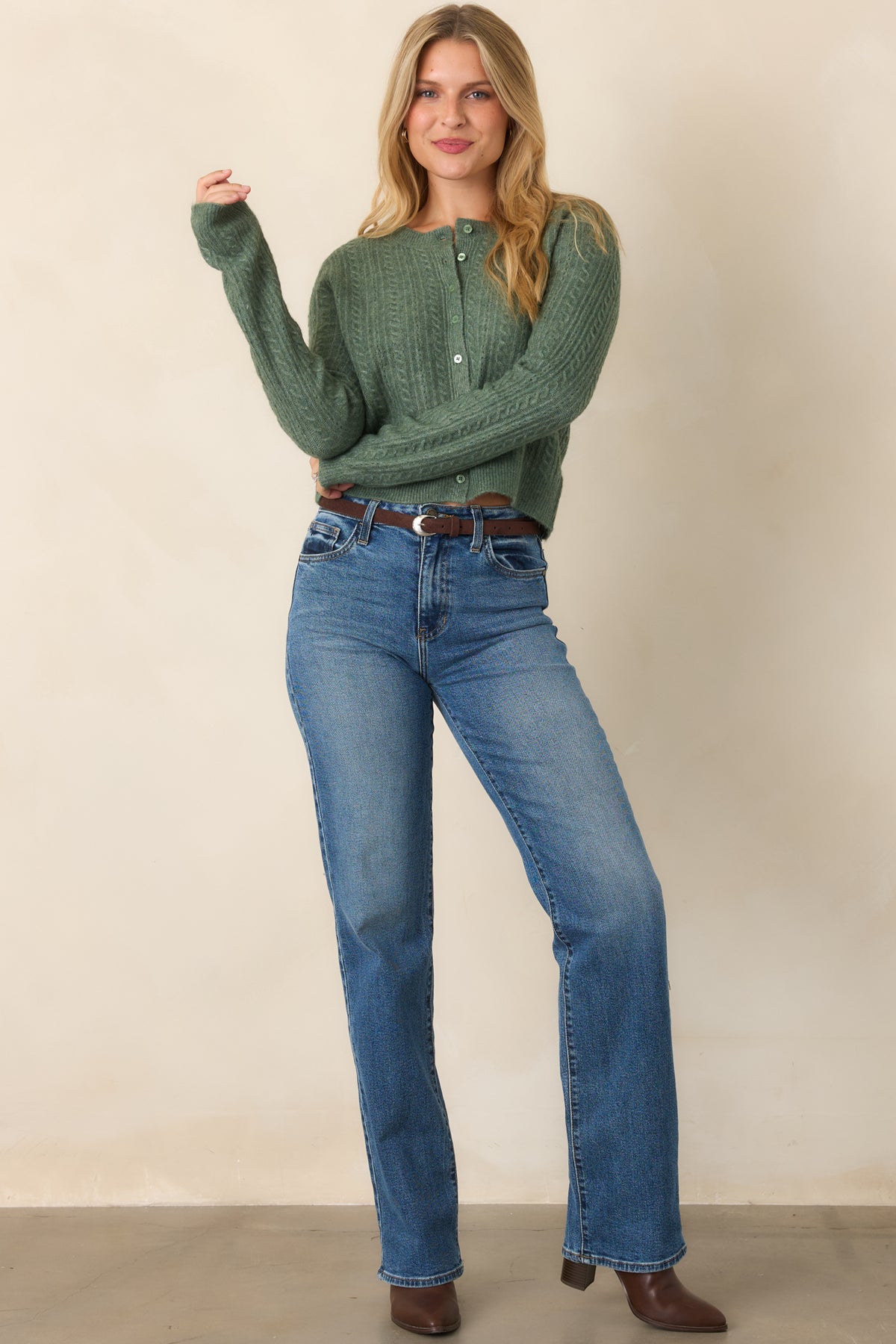 Soft knit cardigan with tonal front buttons, long sleeves, a rounded neckline, and structured ribbed trim framing the cuffs and hem.