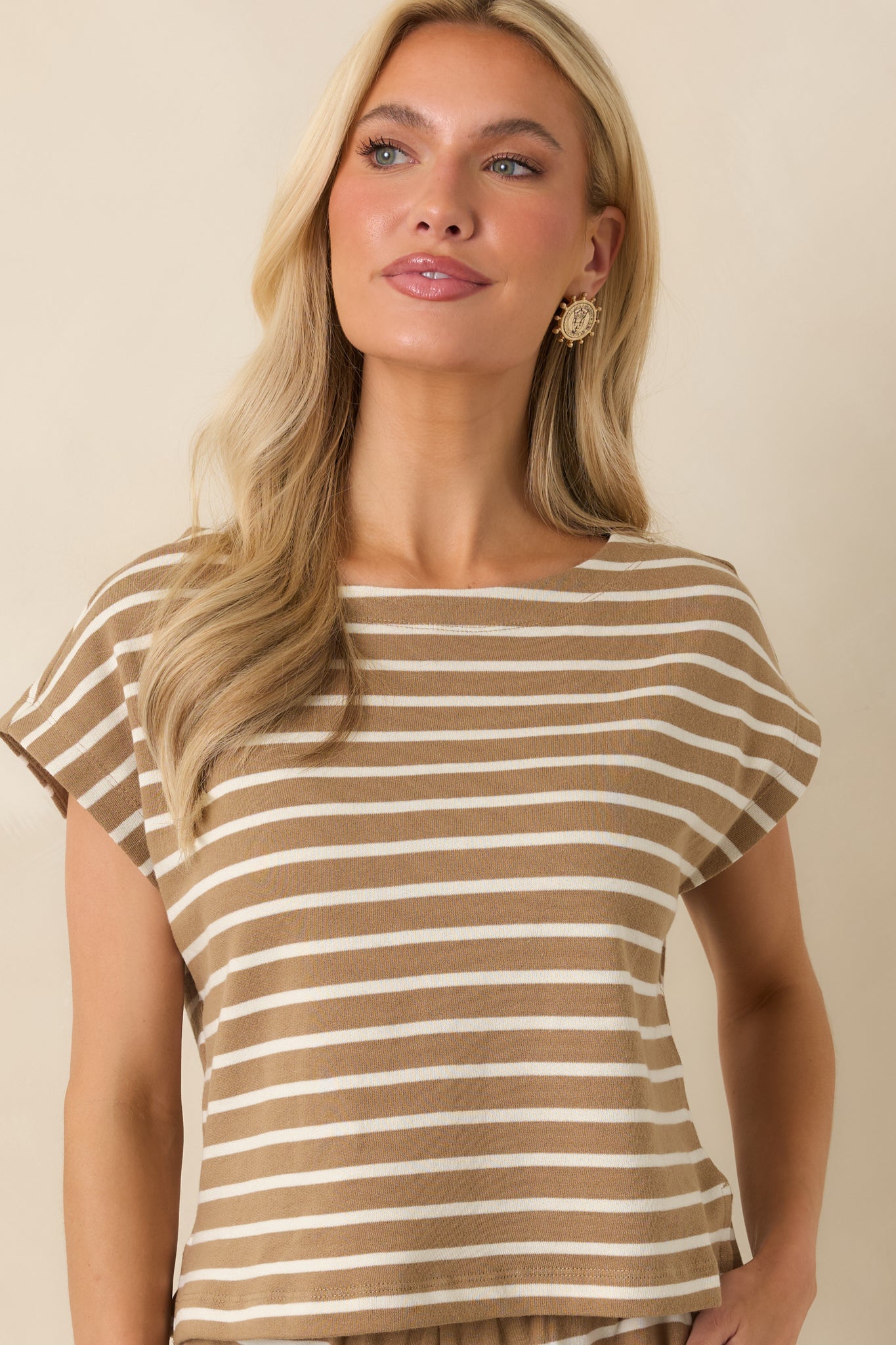 Closer view of the soft knit construction, cap sleeve detailing, and neutral striped color combination.