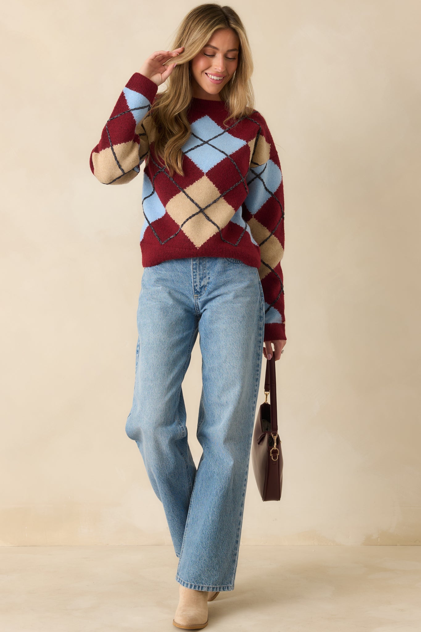 Soft long-sleeve sweater featuring ribbed trim and vibrant argyle design.