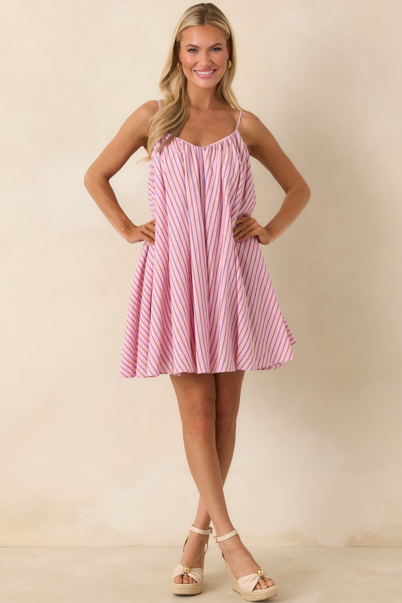 Soft pink striped dress featuring airy drape and gathered neckline detail.