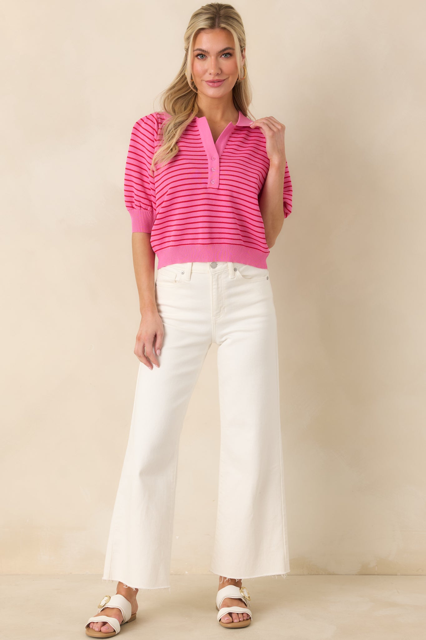 Soft pink striped polo featuring ribbed cuffs and hem, puff sleeves, and a relaxed, classic knit silhouette.