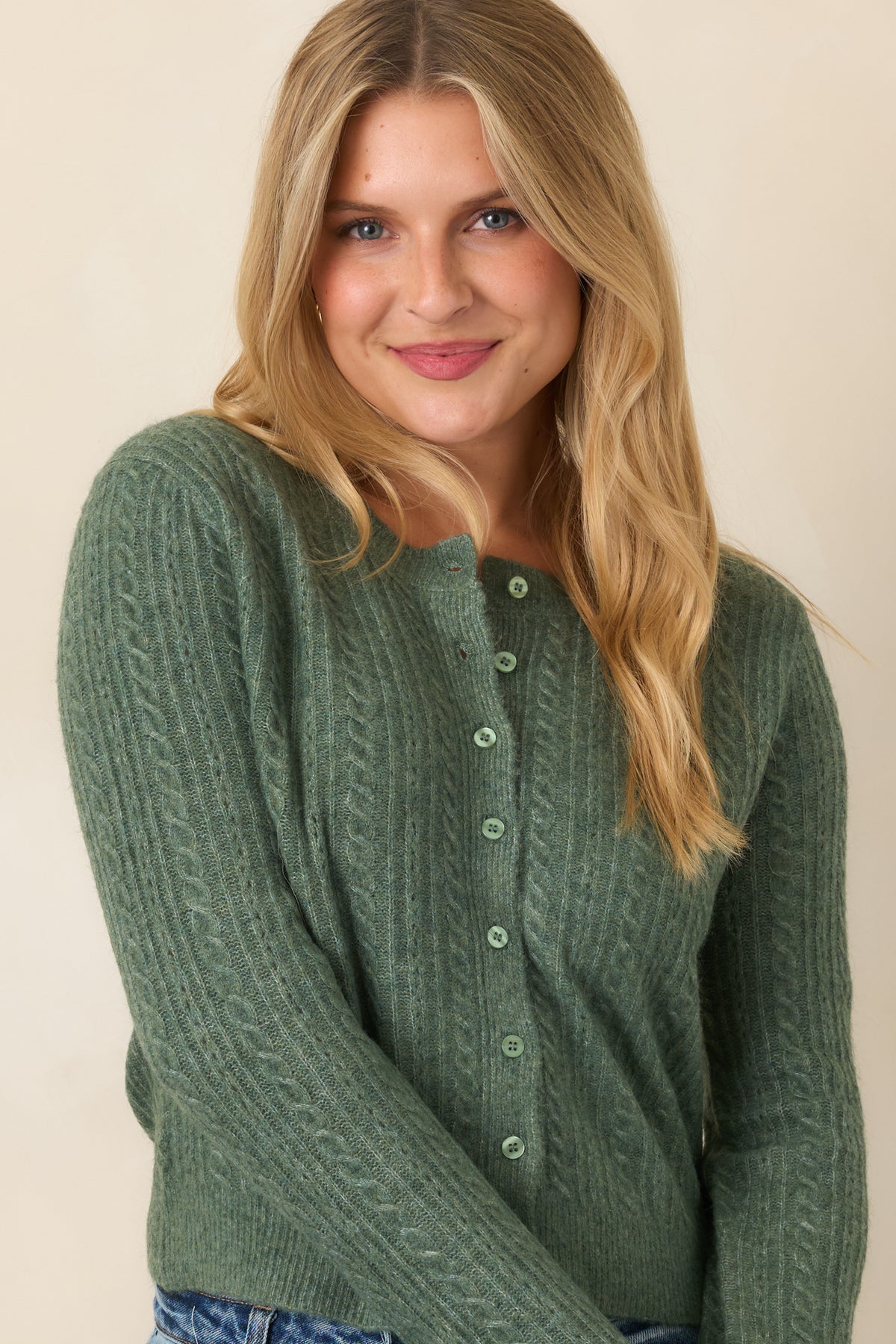Soft stretch cardigan featuring a clean button-front closure, slightly cropped hem, and ribbed detailing along the edges.