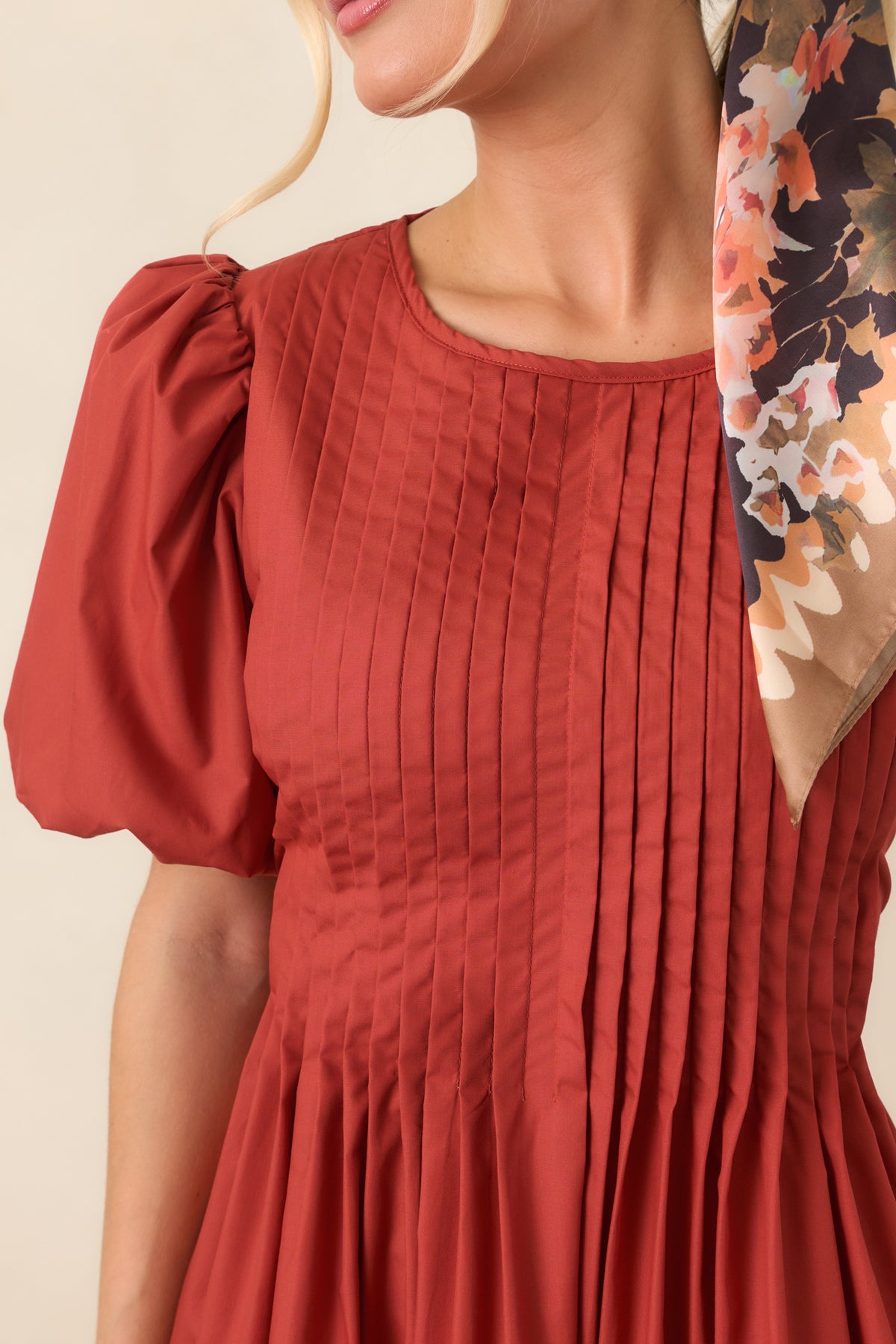 The softly gathered skirt creates a full silhouette beneath the detailed pintucked bodice and short puff sleeves.