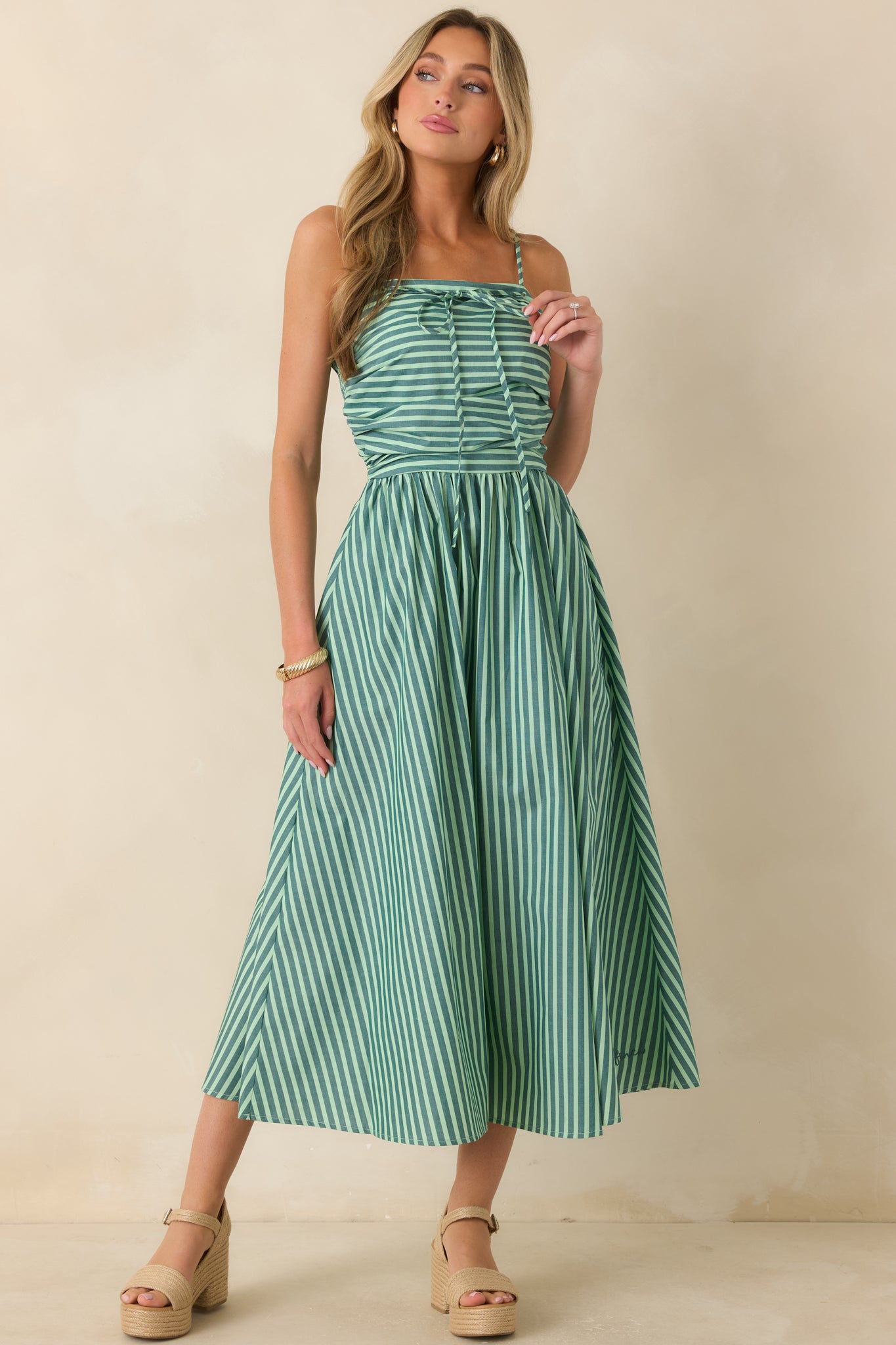 Softly striped cotton maxi dress featuring a fitted ruched bodice, adjustable straps, and a full sweeping skirt with practical side pockets.