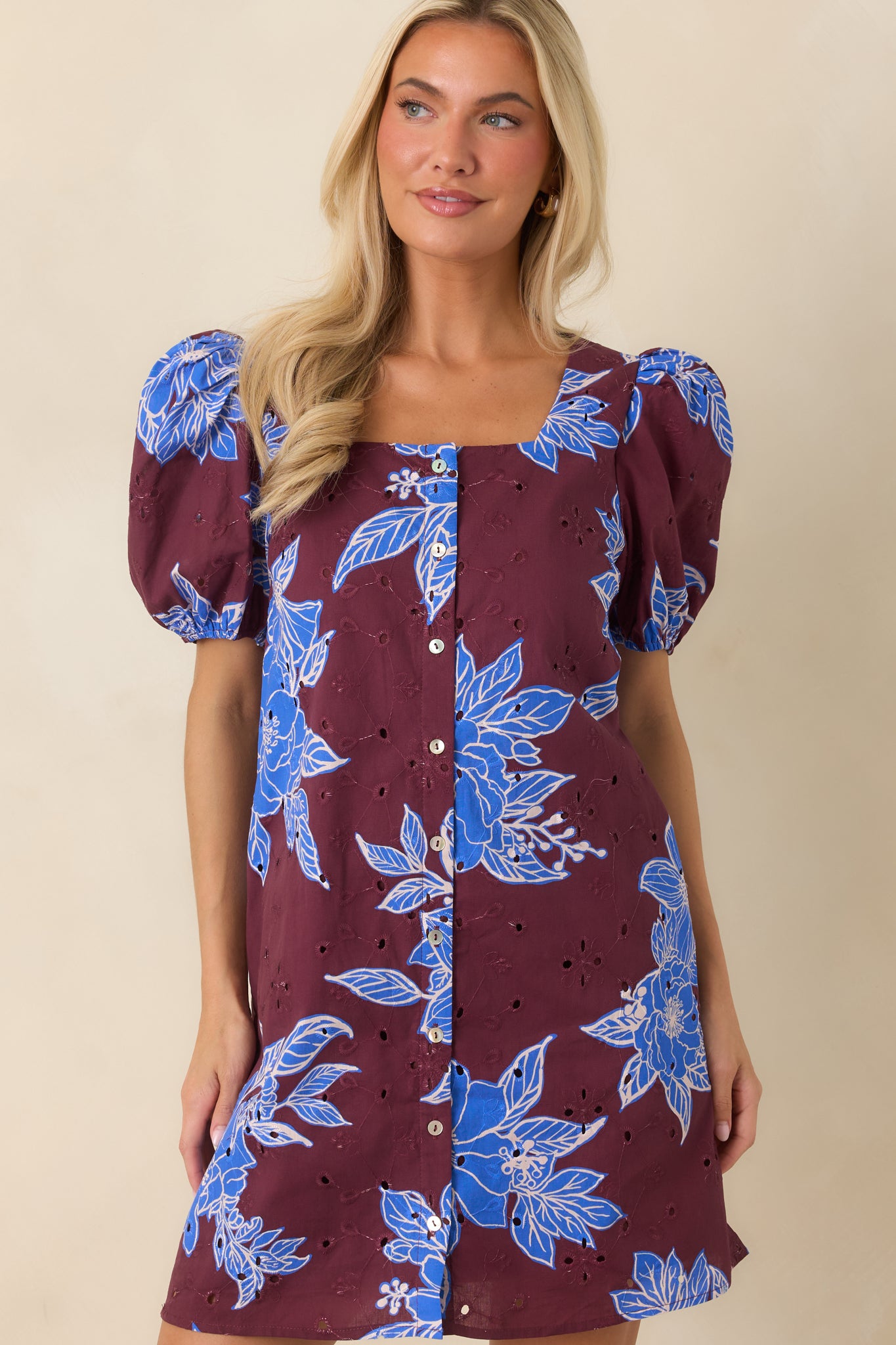 Detailed view of the square neckline, gathered puff sleeves, and eyelet embroidery on the mini dress.