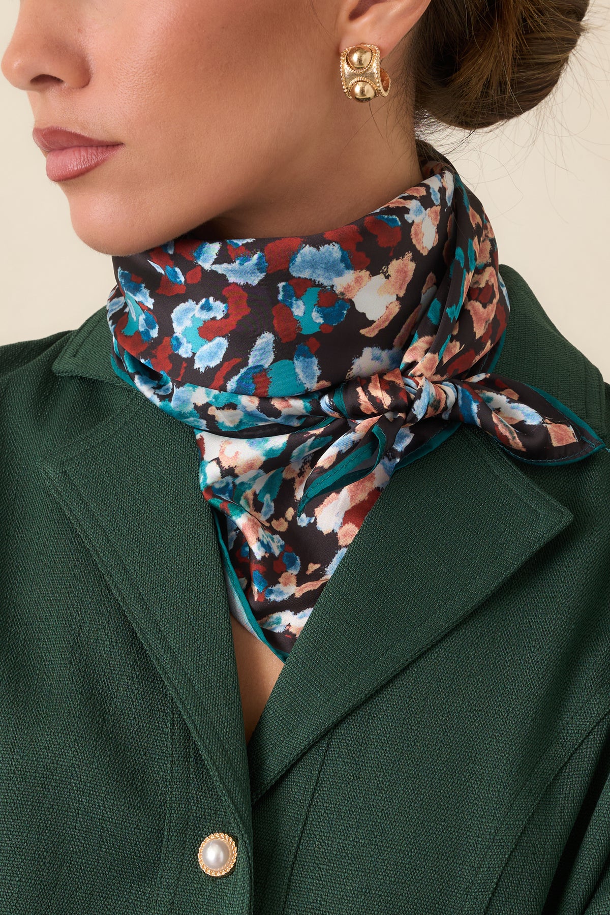 Square scarf highlighting the teal, blue, rust, peach, and ivory abstract pattern against black.