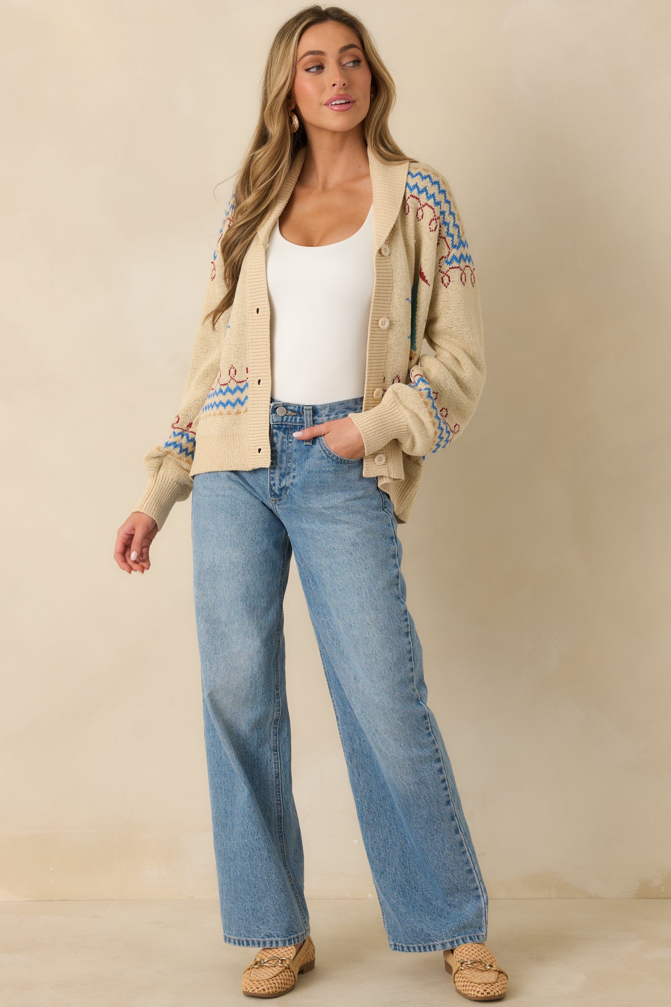 Straight-on front angle showing the contrast zigzag striping and allover patterned knit of the light beige cardigan.