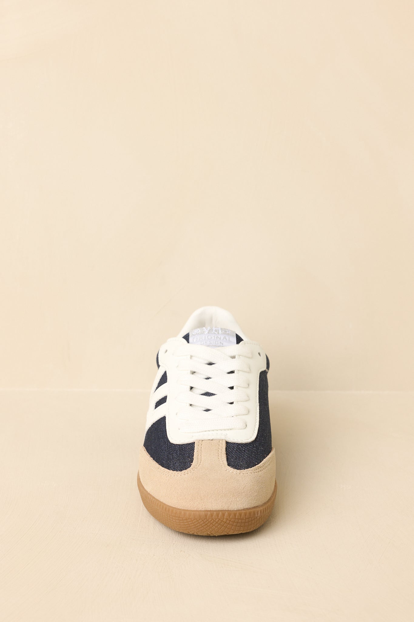 Straight on view of sneakers showing classic lace-up design and layered mixed-material construction.