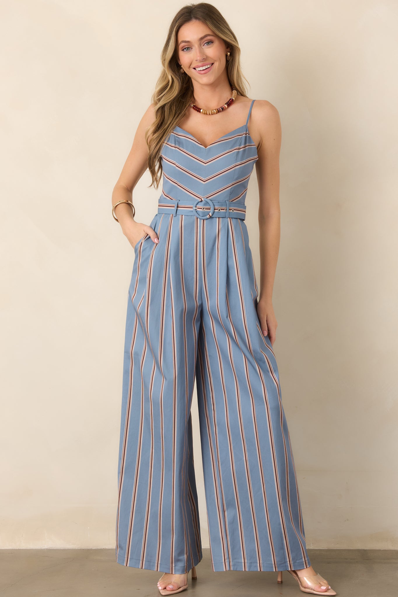 Stretch cotton-blend jumpsuit highlighting its geometric chevron bodice, vertically striped trousers, cinched waist, and functional side pockets.
