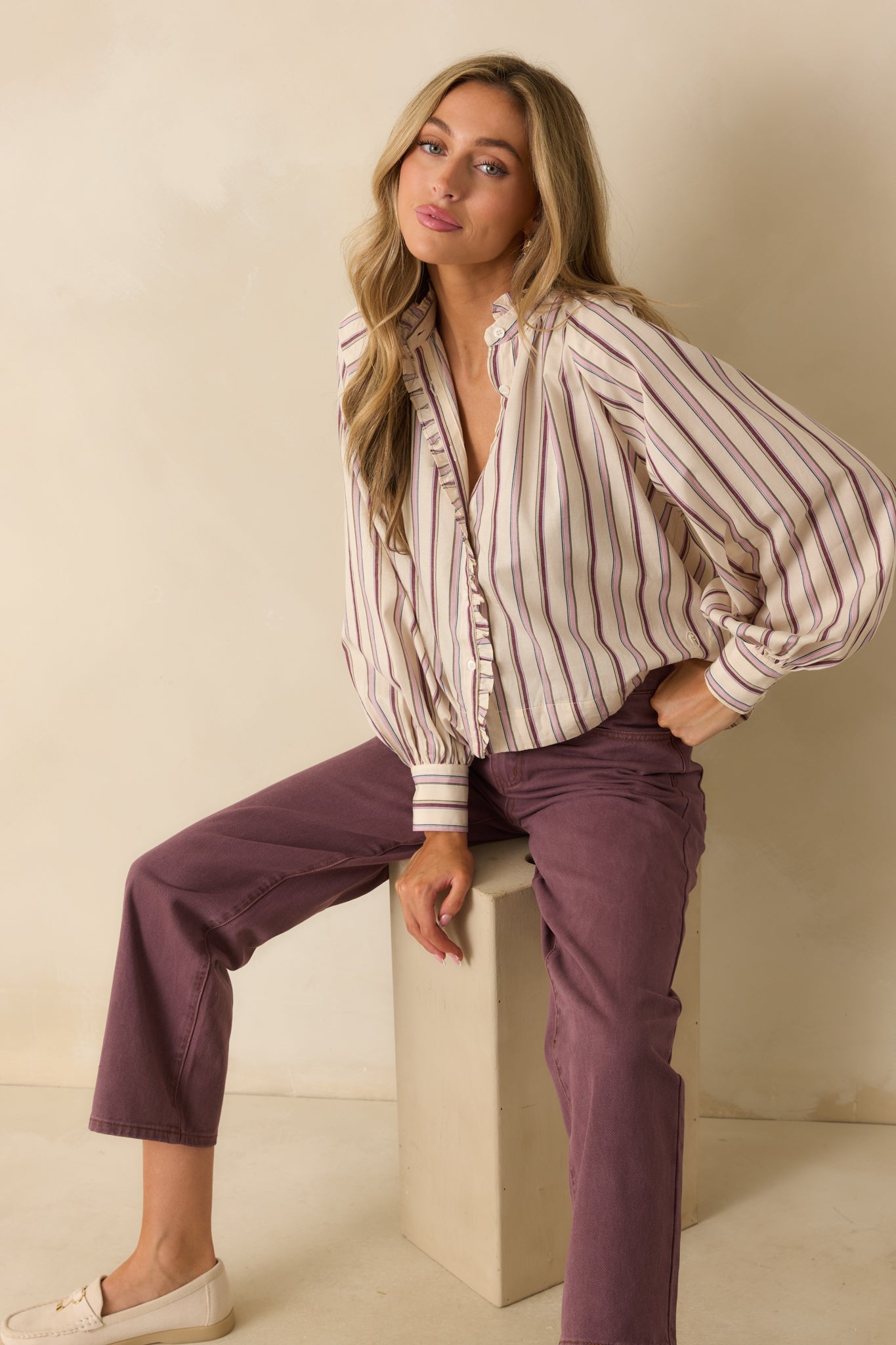 Ivory and lilac striped button-up shirt styled loose, highlighting the flowing silhouette and curved hemline.
