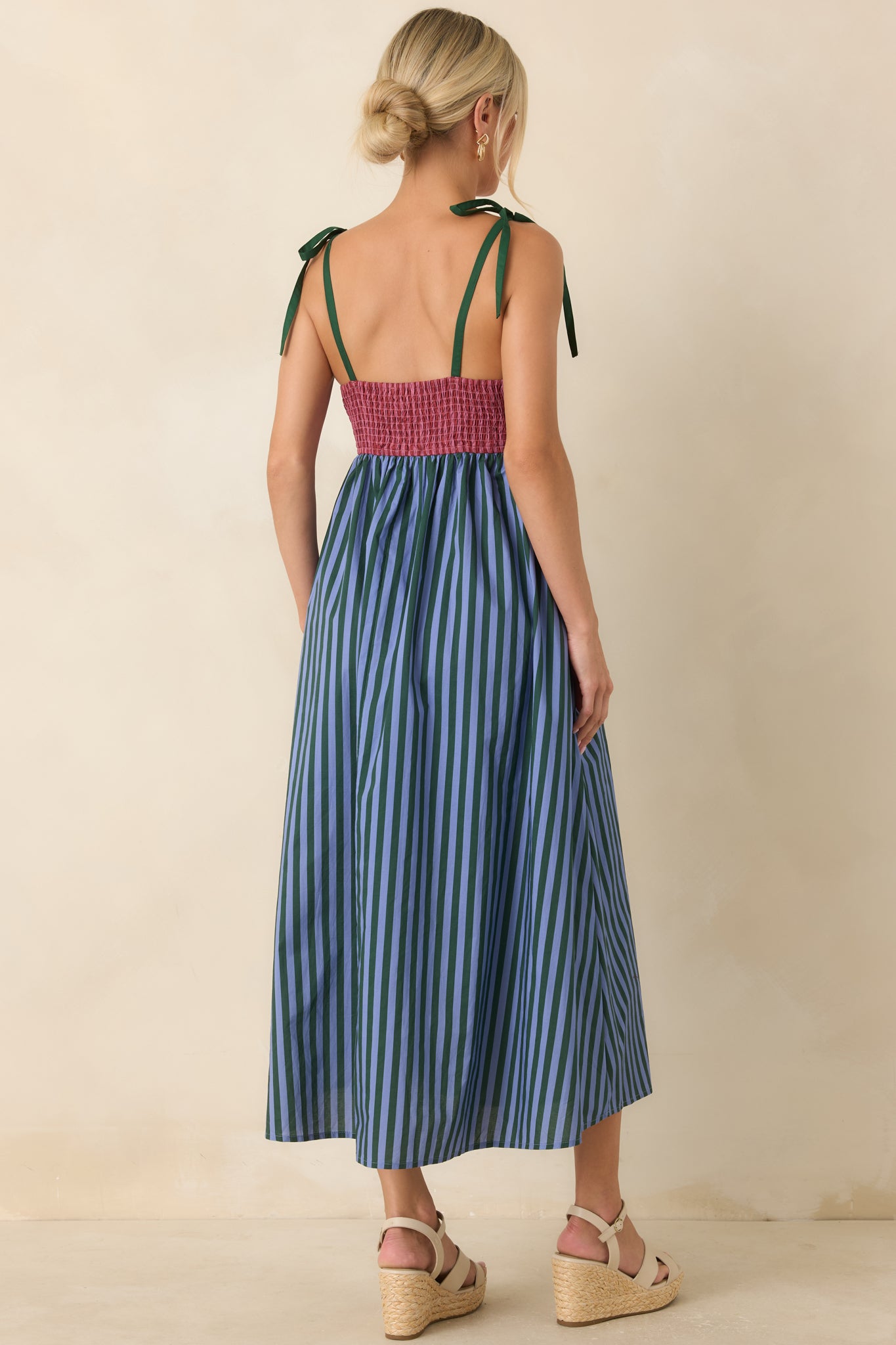 Back of the striped midi dress featuring adjustable tie straps, a comfortable smocked panel, and gathered skirt.