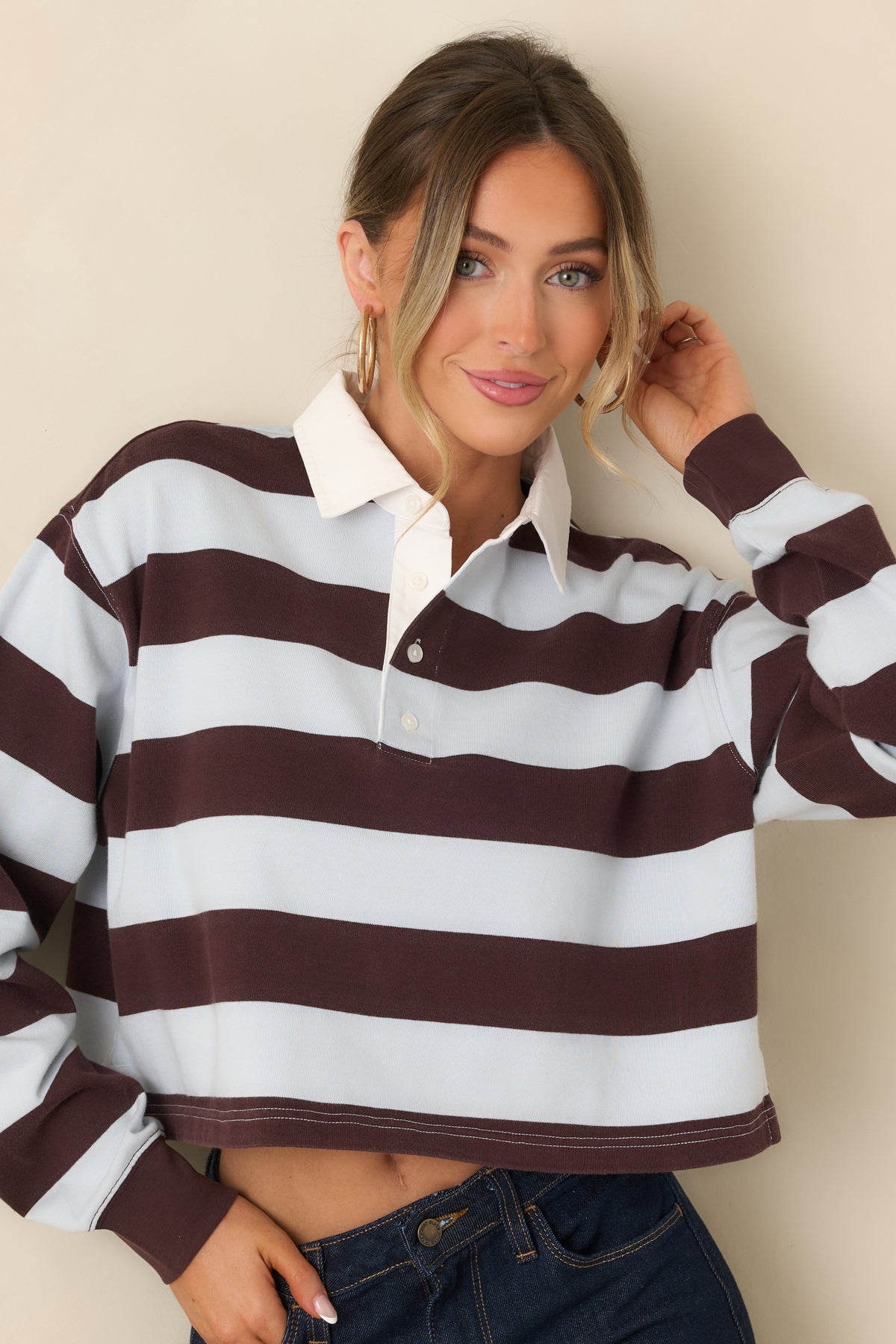 Casual striped top with relaxed shoulders, long sleeves, and a sporty collared neckline.