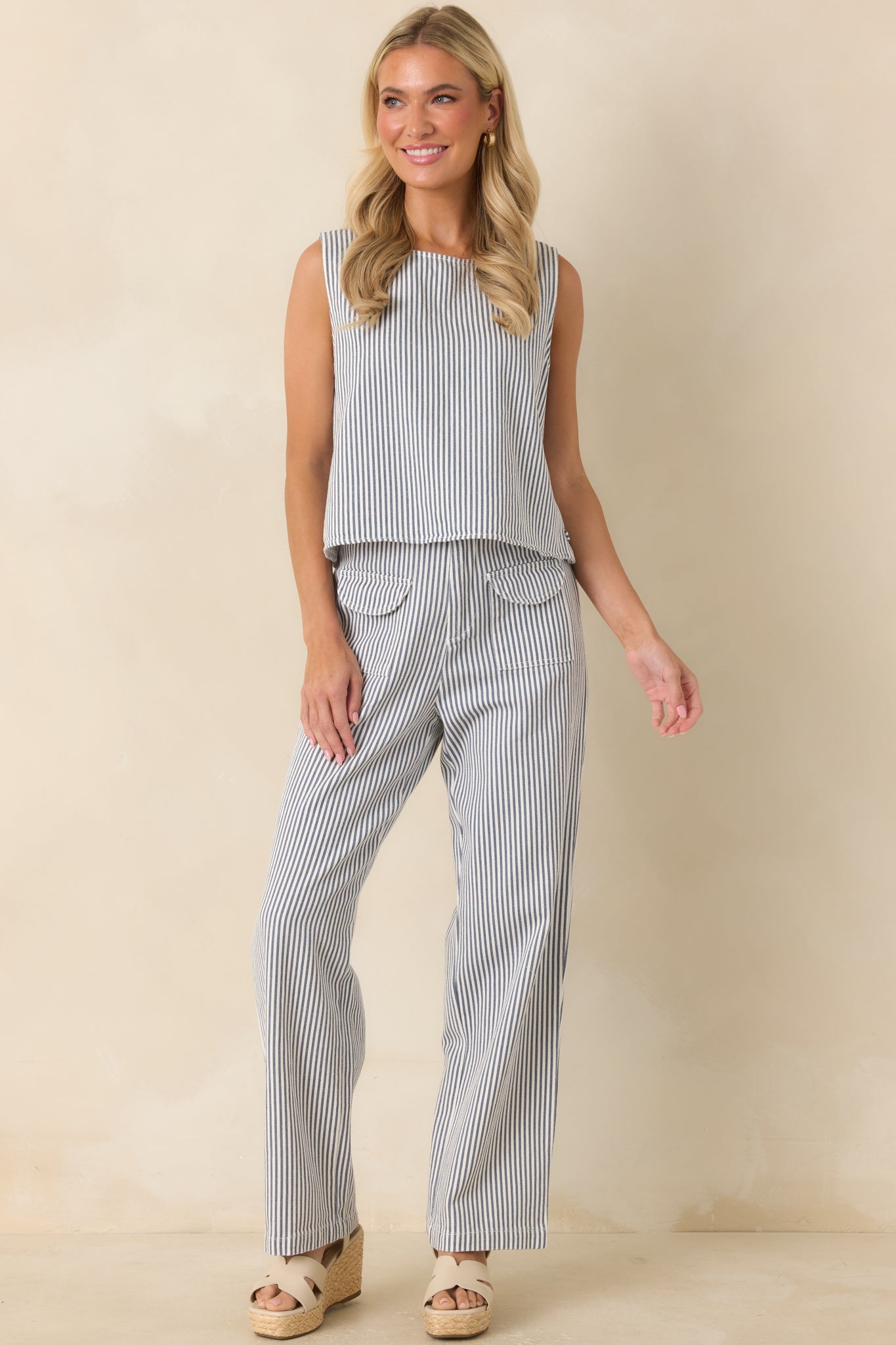 Striped top featuring a comfortable relaxed shape, ivory and blue stripes, and subtle side button accents.