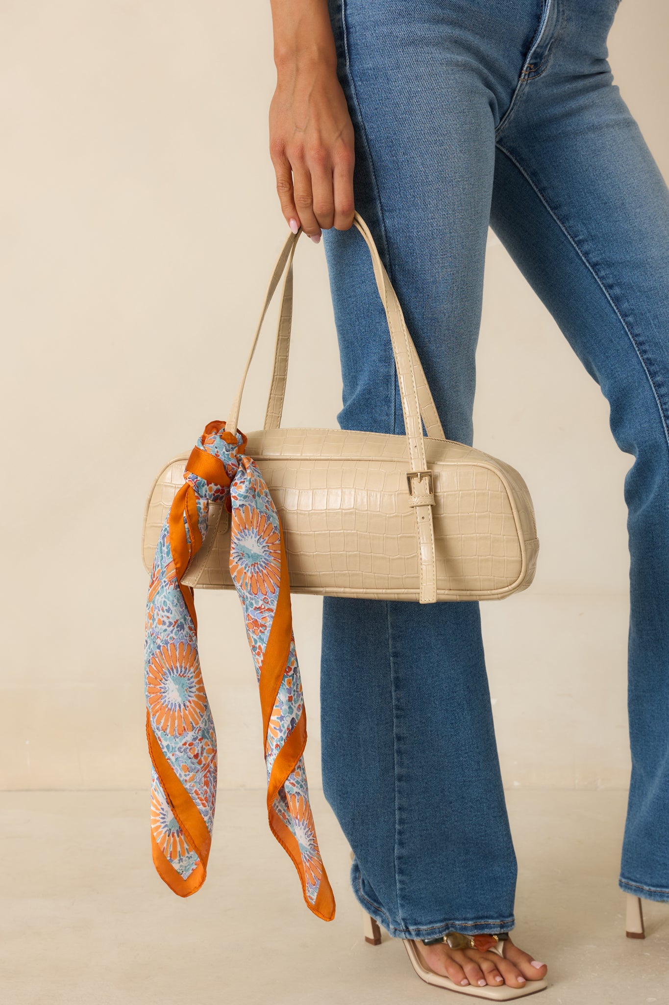 Structured beige handbag showcasing faux crocodile leather texture, a spacious single compartment, and classic top handles.