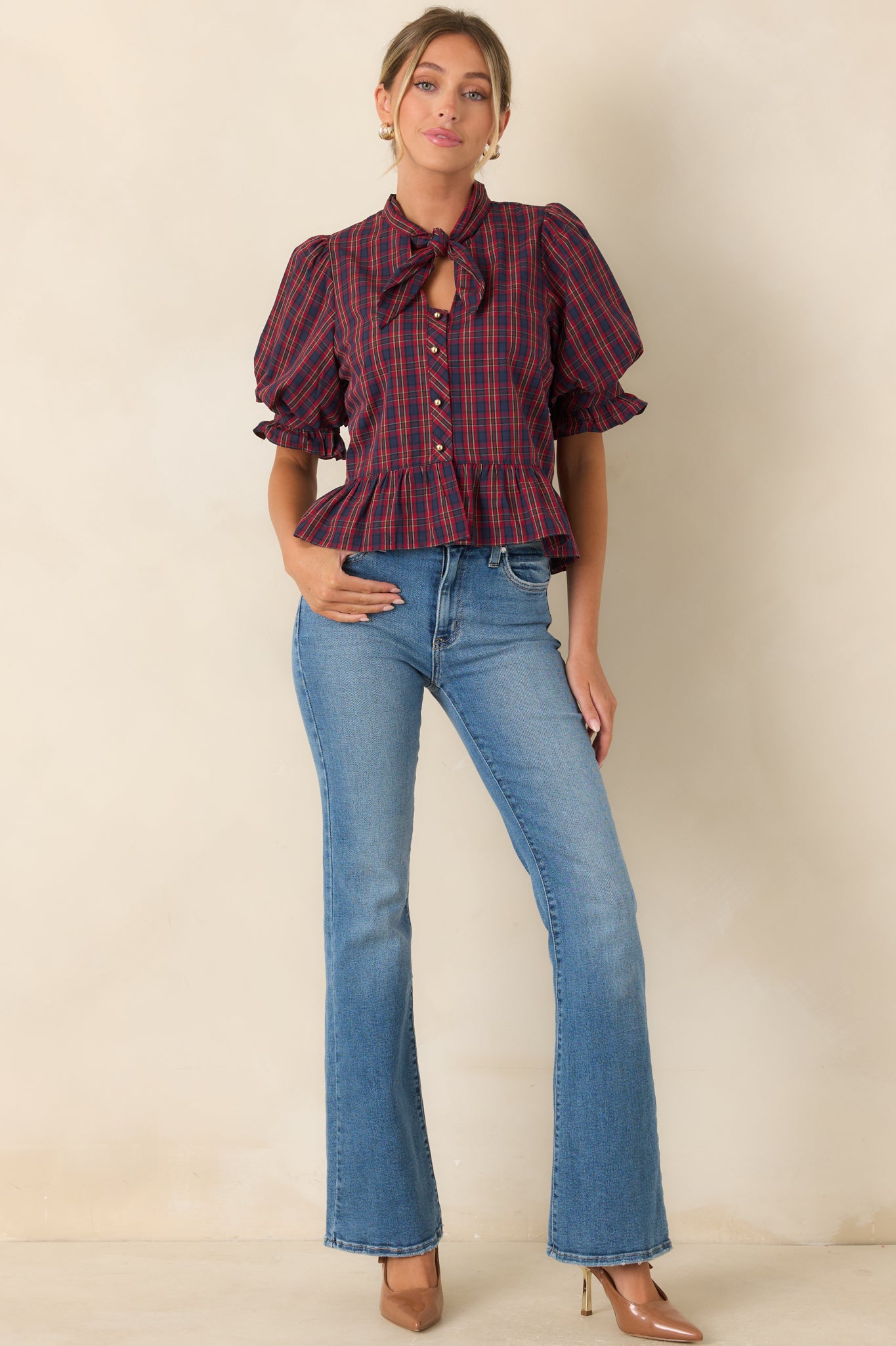Structured blouse featuring a button-front design, voluminous sleeves, and a flattering peplum shape.