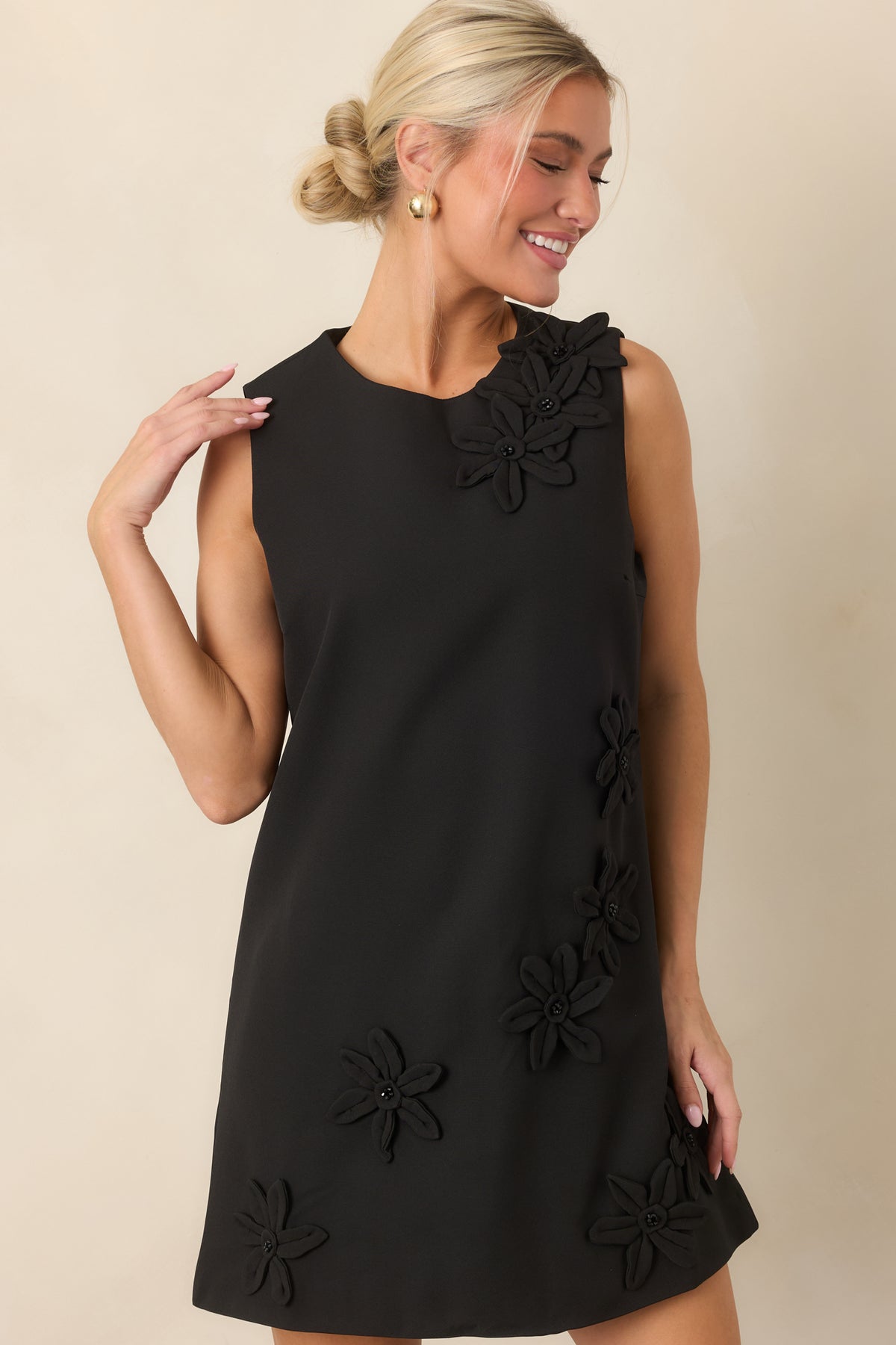 Structured bodice with scattered three-dimensional floral appliqués and a classic round neckline.