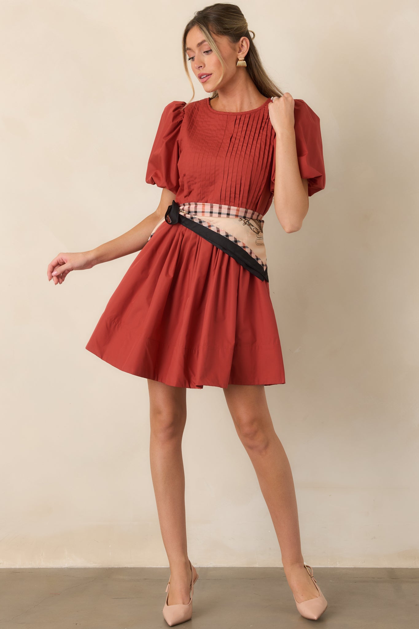 Structured mini dress showcasing intricate pintucks, rounded puff sleeves, a defined bodice, and a flowing gathered skirt.