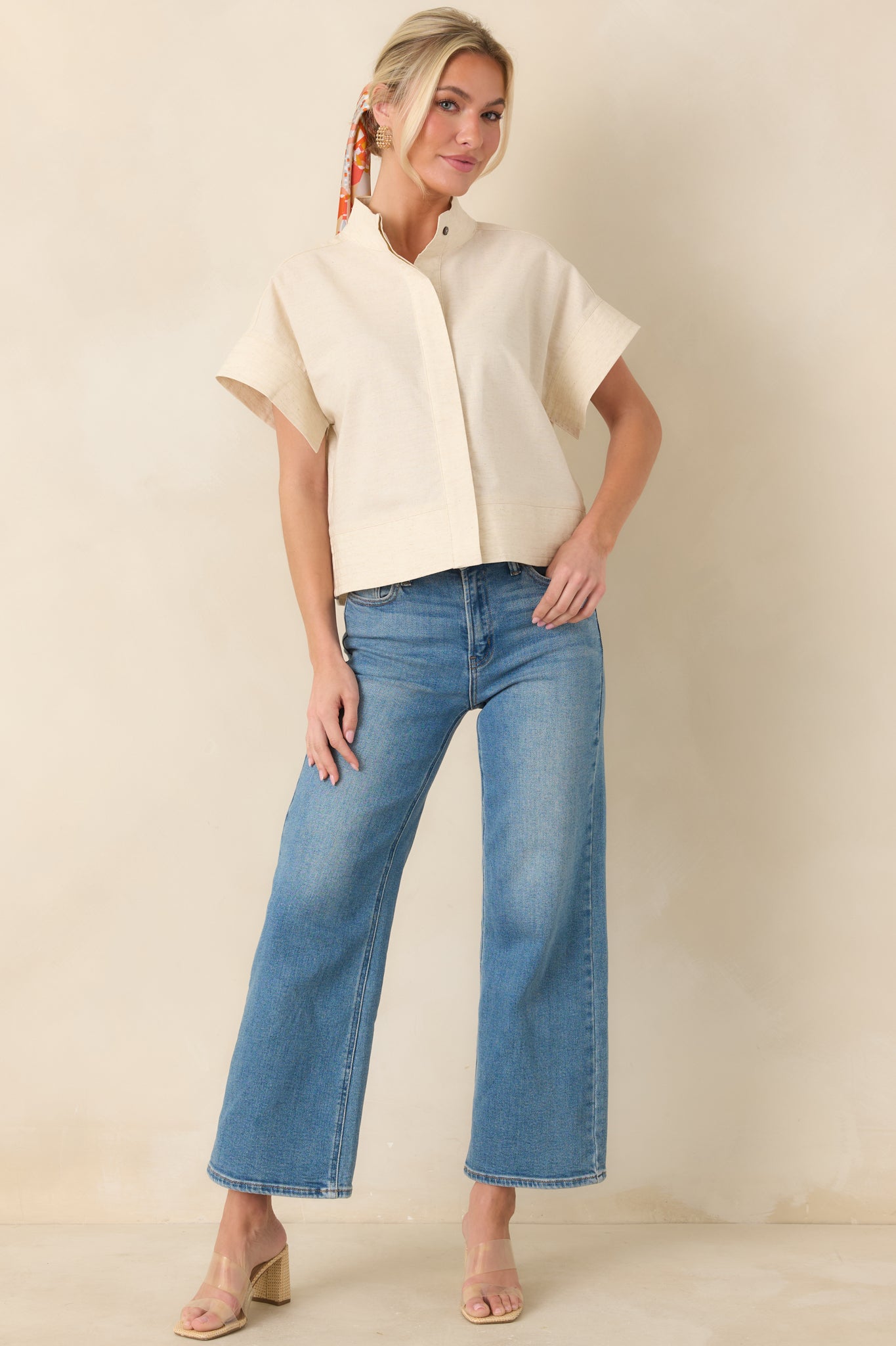 Structured natural woven top with mock neckline and concealed button-front placket.