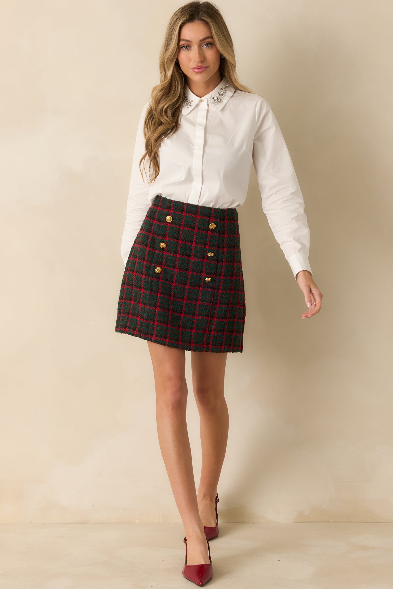 Structured plaid tweed skirt with a defined high waist and decorative gold buttons along the front.