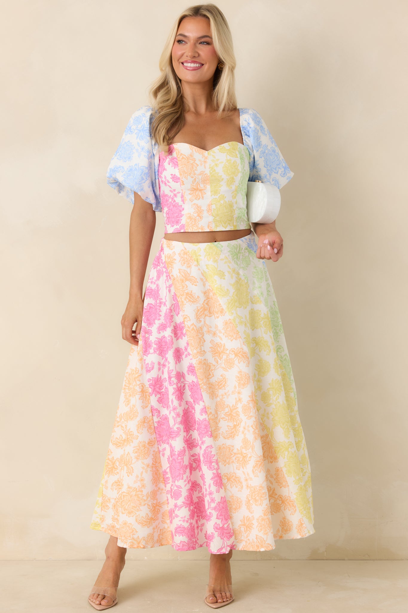 Structured top featuring fitted bodice, vibrant floral print, and voluminous puff sleeves.