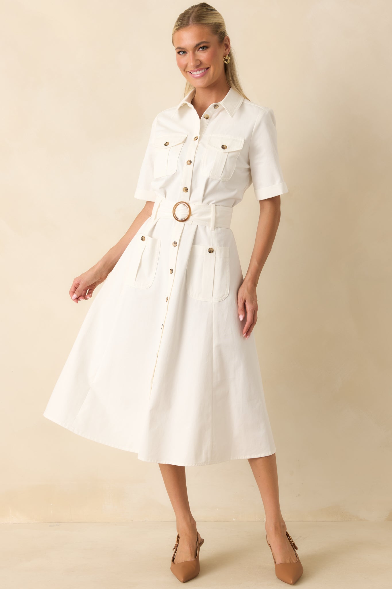 Midi dress crafted from structured cotton twill featuring a statement buckle belt and functional pocket accents.