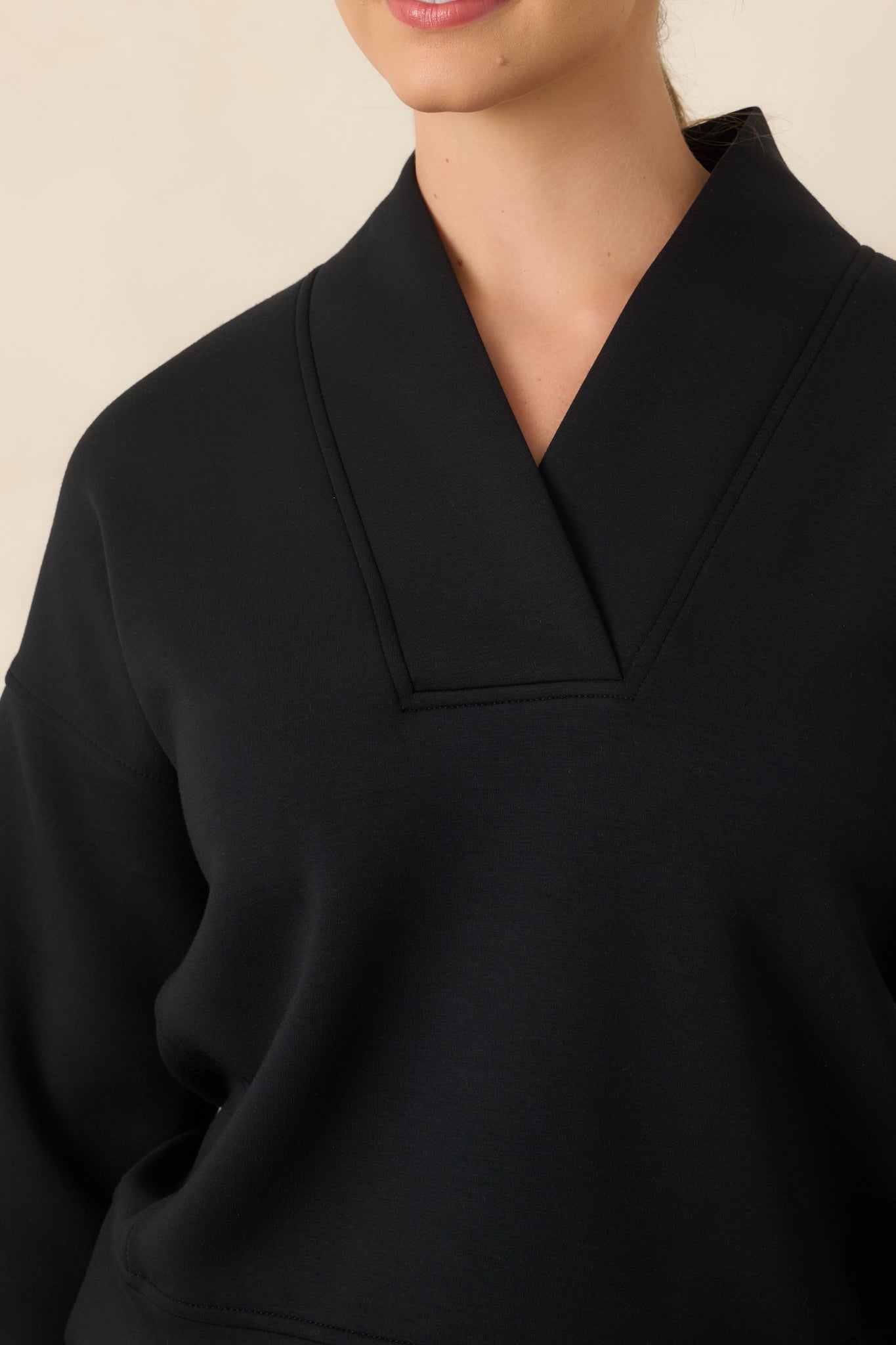 Close-up of the structured V-neckline and wide collar detailing at the upper top.