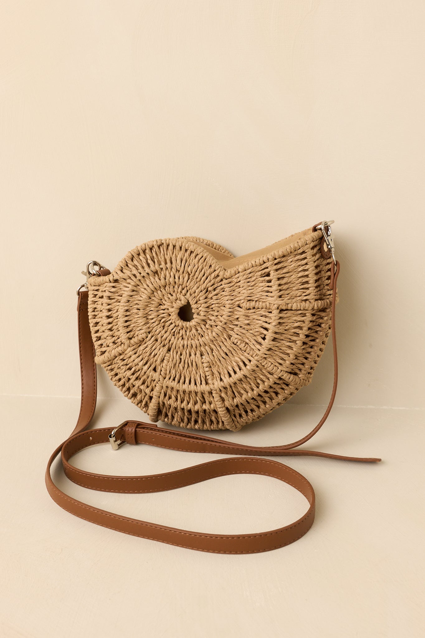 Structured woven crossbody featuring a unique spiral silhouette, zipper closure, and lightweight everyday design.