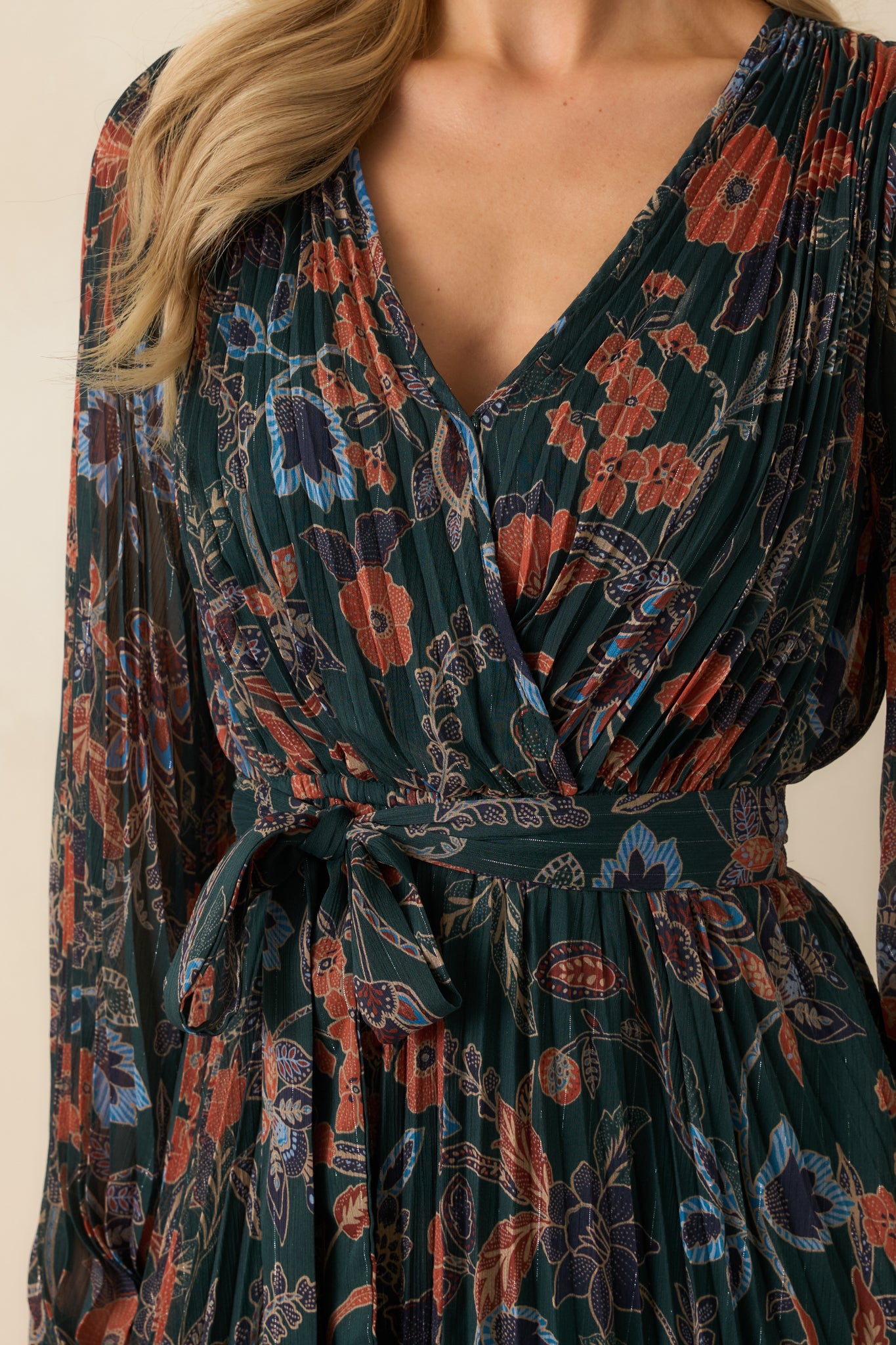 Close-up of the surplice wrap bodice, floral pattern, and sheer long sleeves with elastic cuffs.