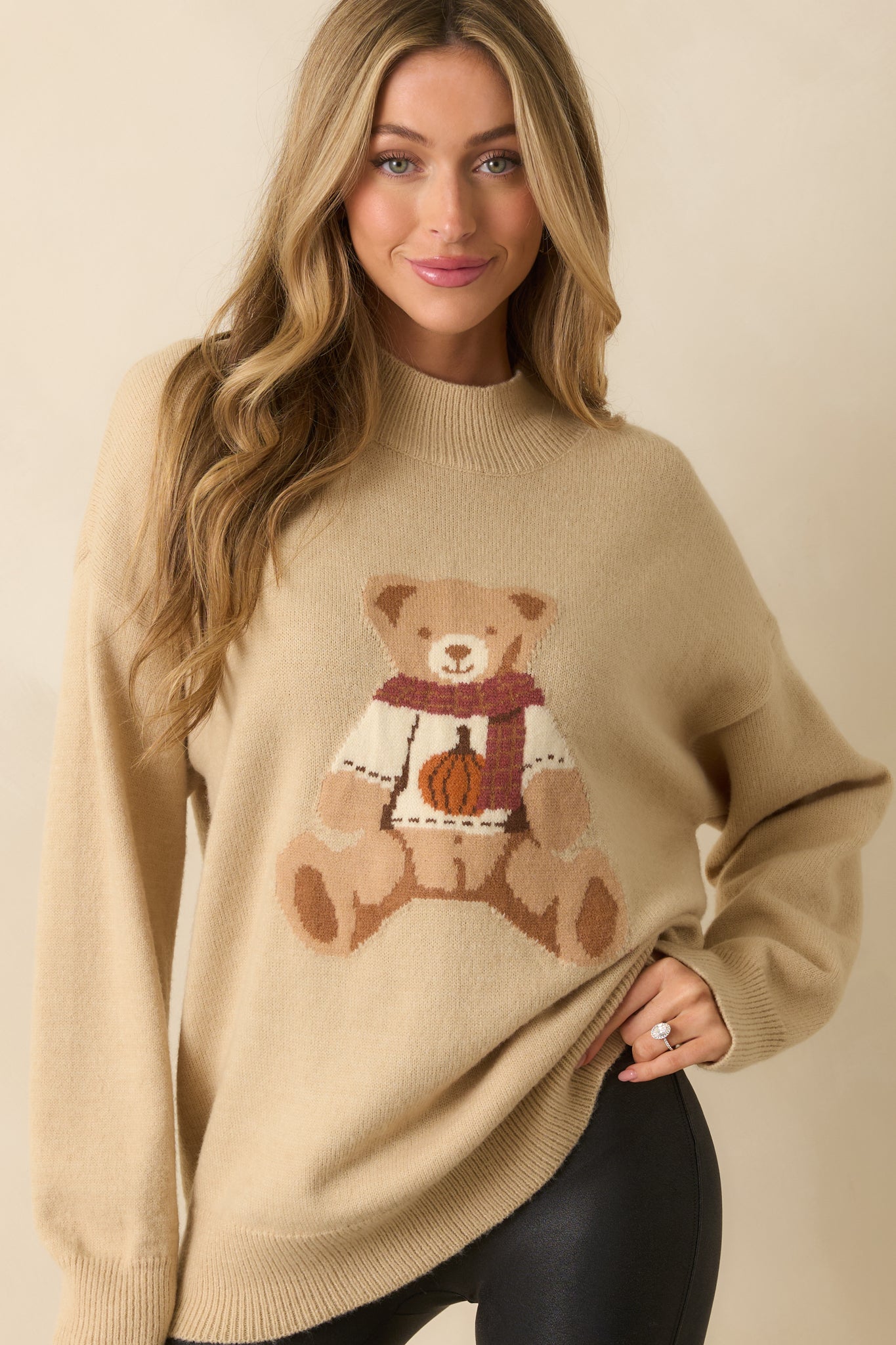 A cropped close-up showing the knit texture and detailed scarf and pumpkin sweater on the teddy bear graphic.